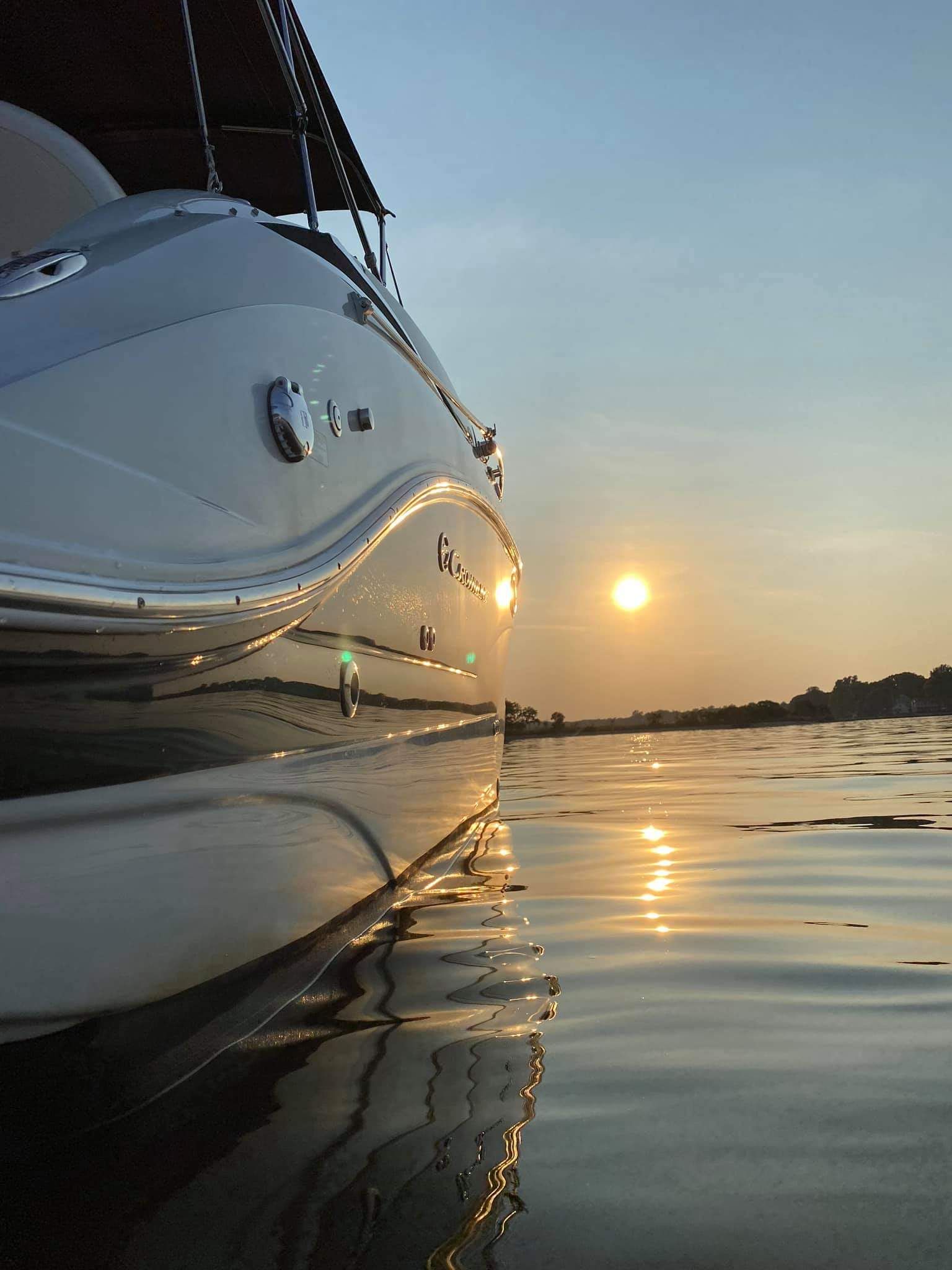 2017 Crownline 285SS on calm water at sunset.