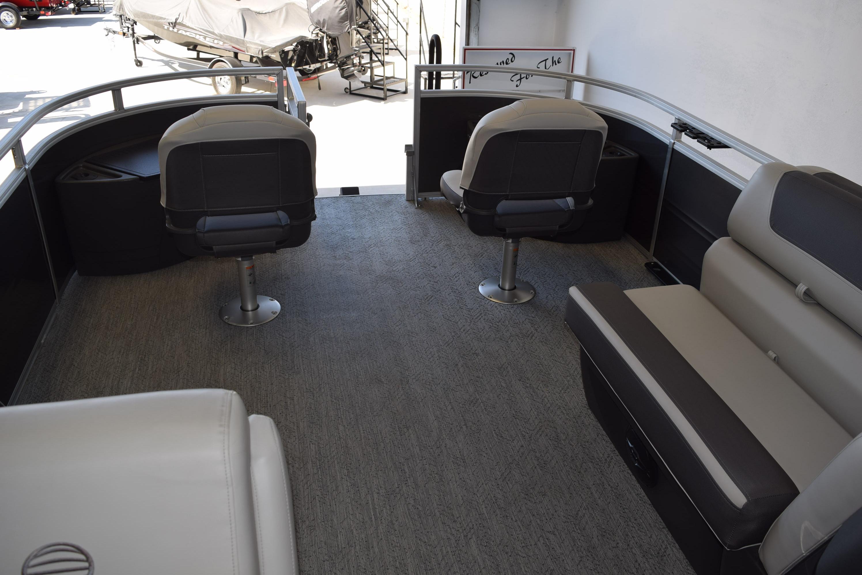 2026 Sun Tracker Fishin' Barge 22 DLX interior with seating and fishing chairs.