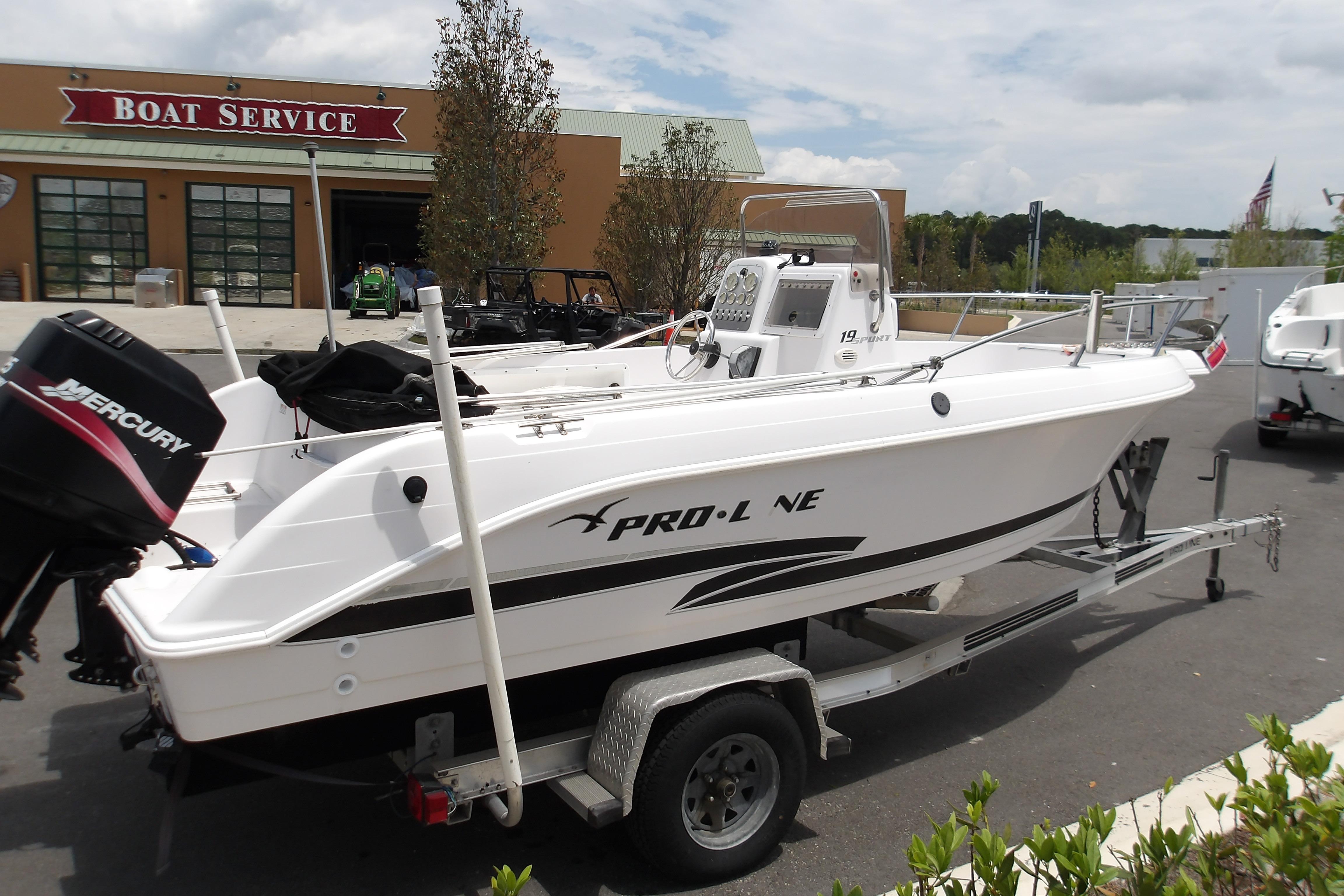2000 Pro-Line 19 Sport boat on trailer outside a boat service center.