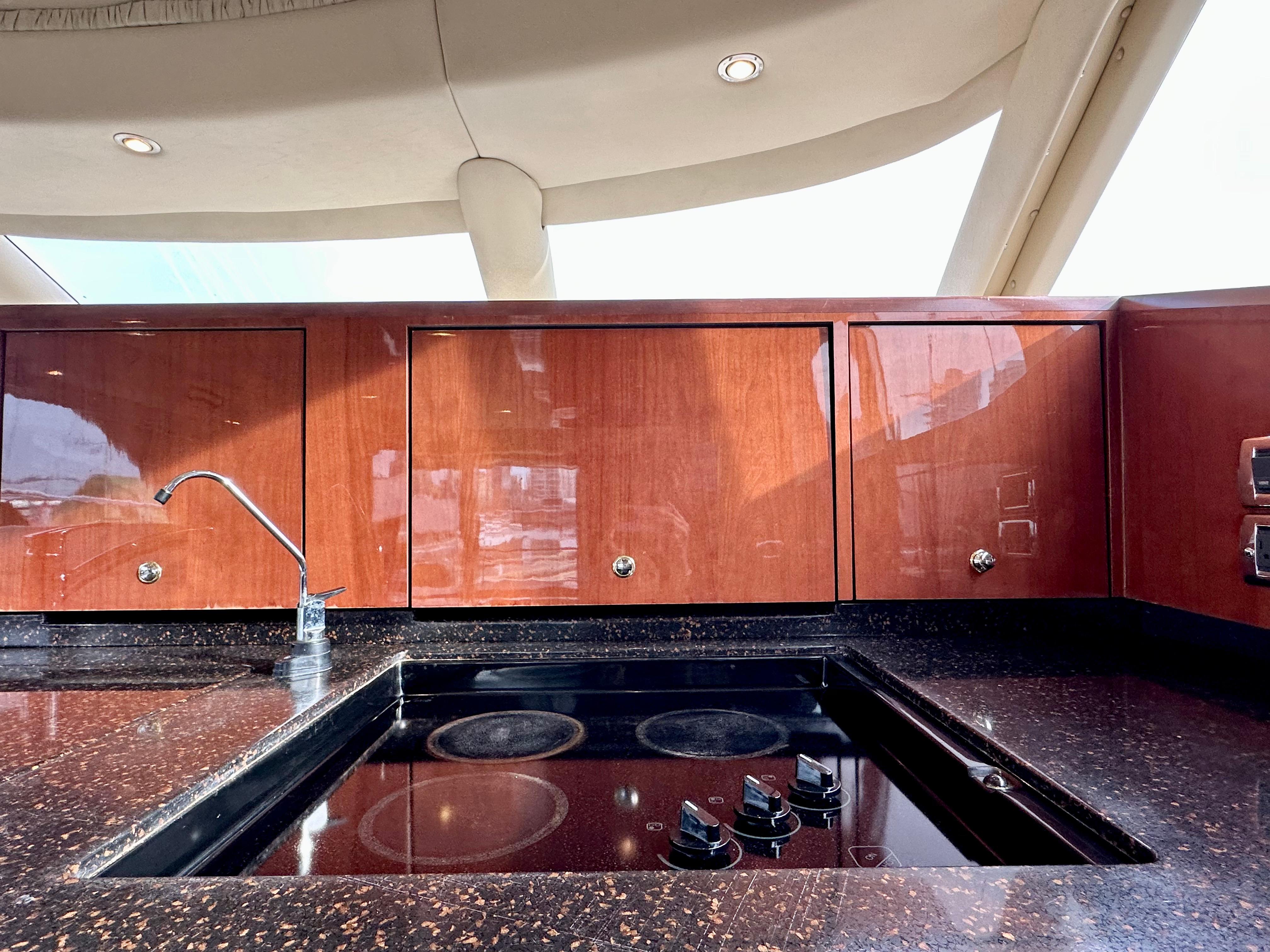 Luxurious kitchen area on a 2002 Sea Ray 560 Sedan Bridge yacht with sleek wood cabinetry.