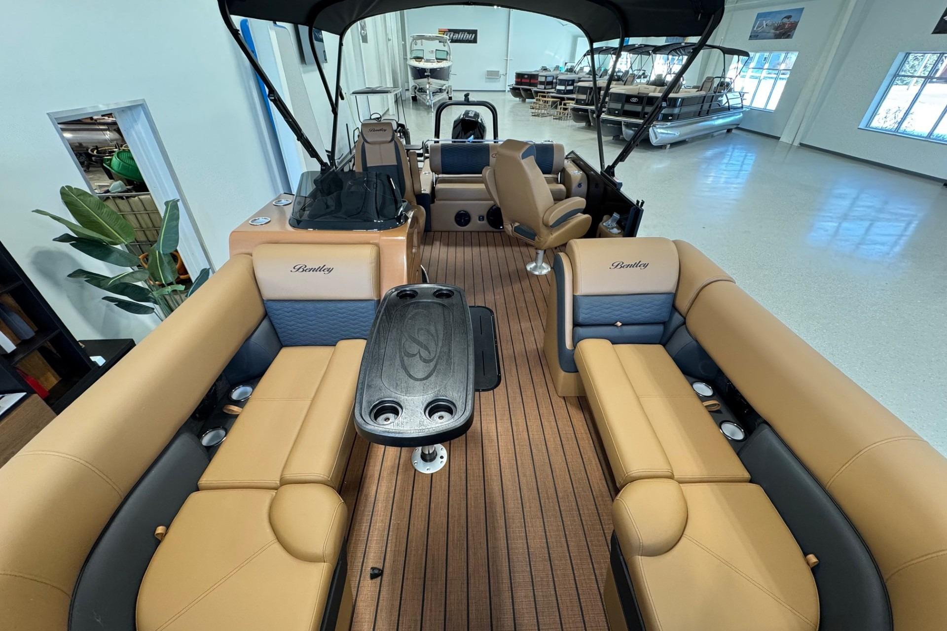 2026 Bentley Pontoons Elite 223 Swingback interior with tan seating and wood-style flooring.