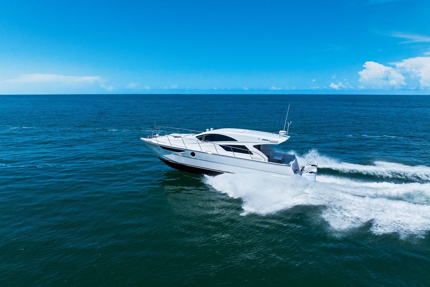 A 2018 Mym/Mares 47 Outboard Express Catamaran speeding across the open sea.