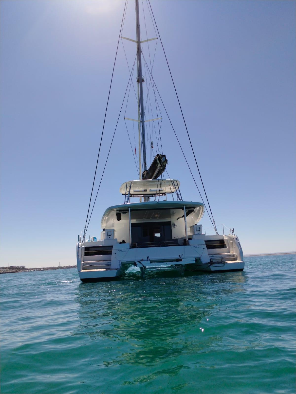 2018 Lagoon 50 catamaran on calm sea under clear blue sky.
