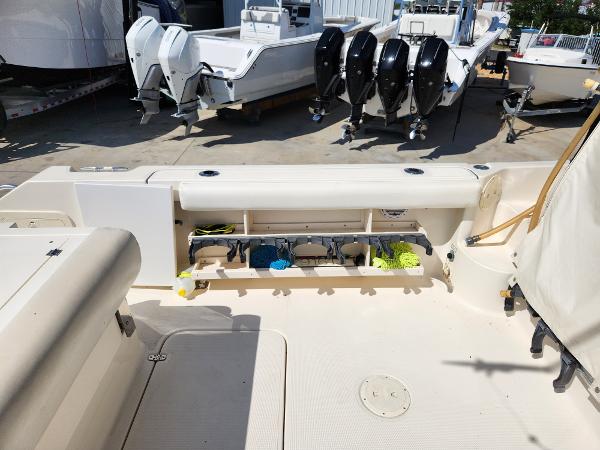 2005 Pursuit 3070 Offshore Center Console boat with open storage compartment and multiple outboard engines.