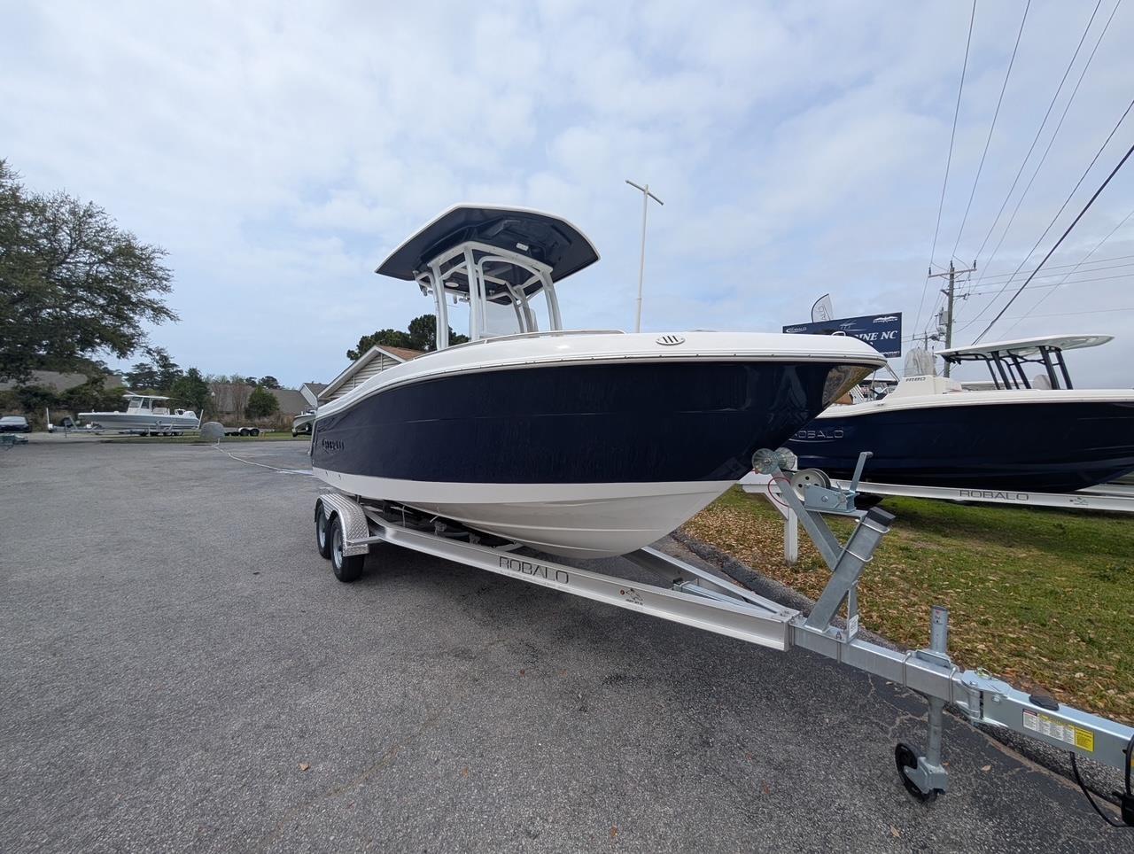 2025 Robalo R222 Explorer boat on trailer, parked outdoors.