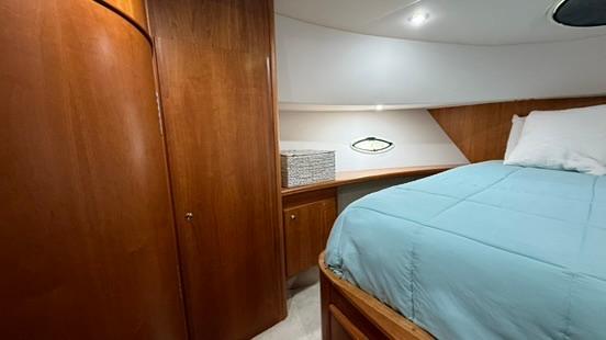 2001 Silverton 410 Sport Bridge cabin with wood paneling and a cozy bed.
