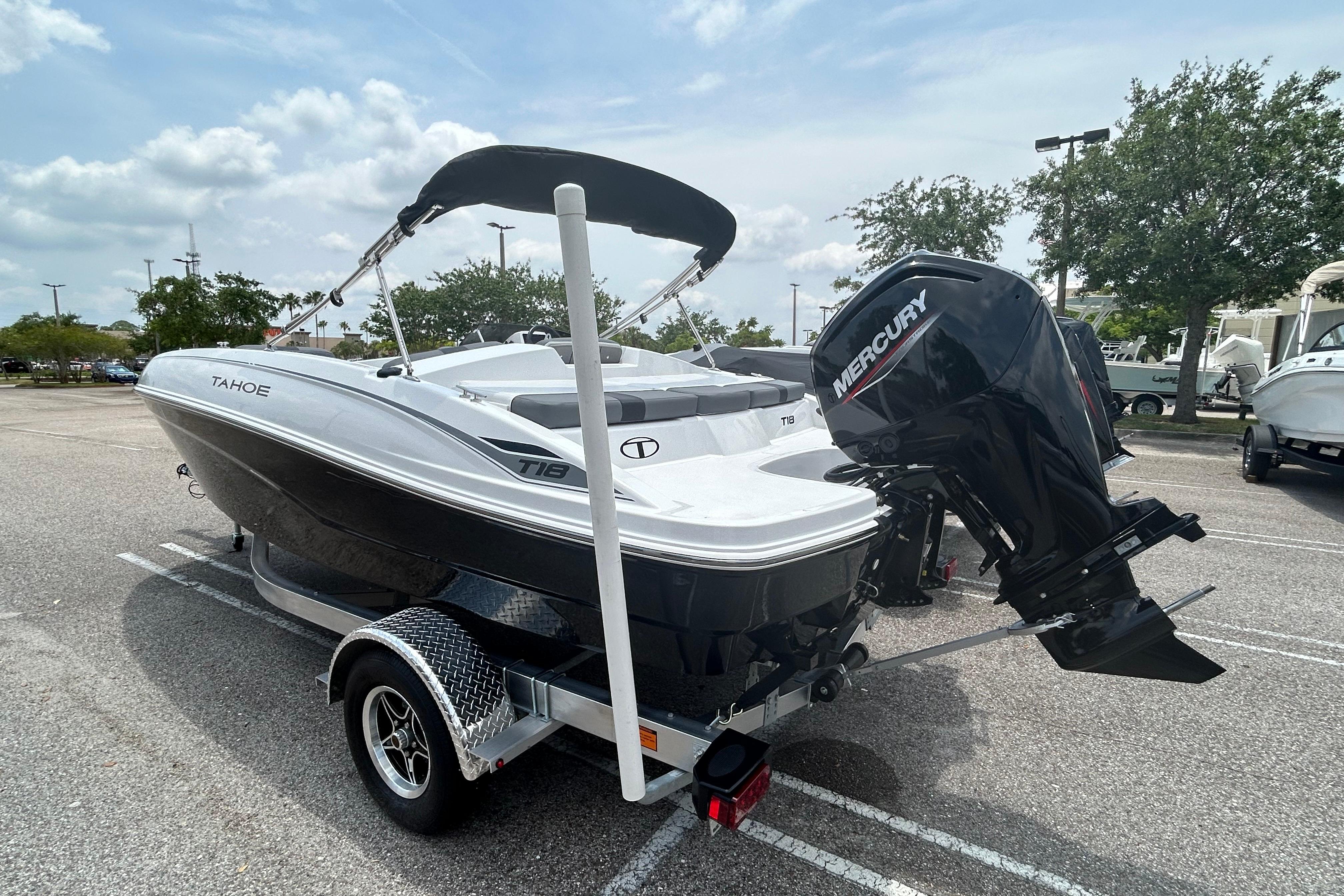 2026 Tahoe T18 boat with Mercury engine on trailer in parking lot.