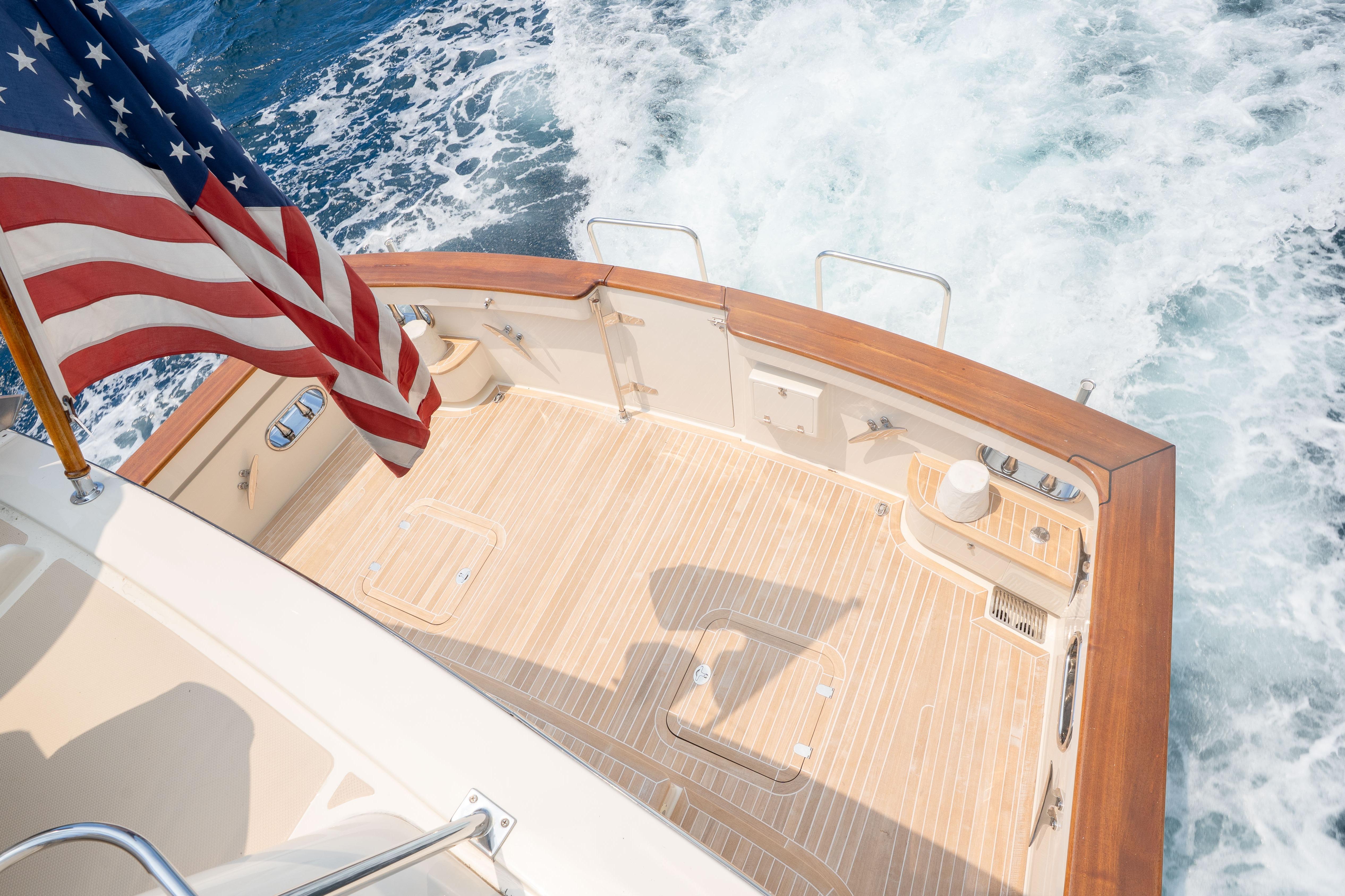 Aft deck of 2006 Fleming 75 yacht with American flag and ocean waves.