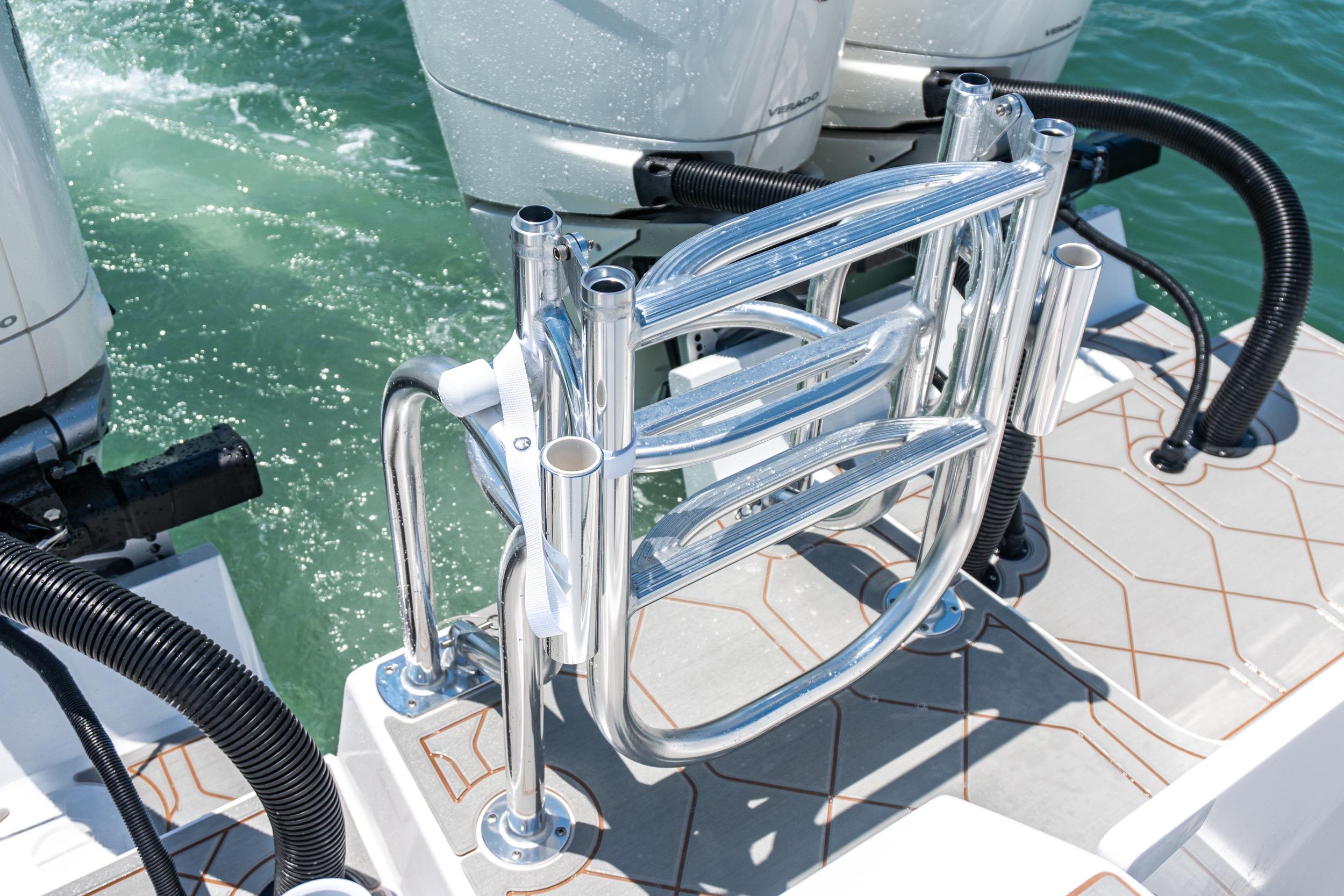 Stainless steel ladder on 2026 Twin Vee 400 GFX2 CC boat, near powerful outboard engines.