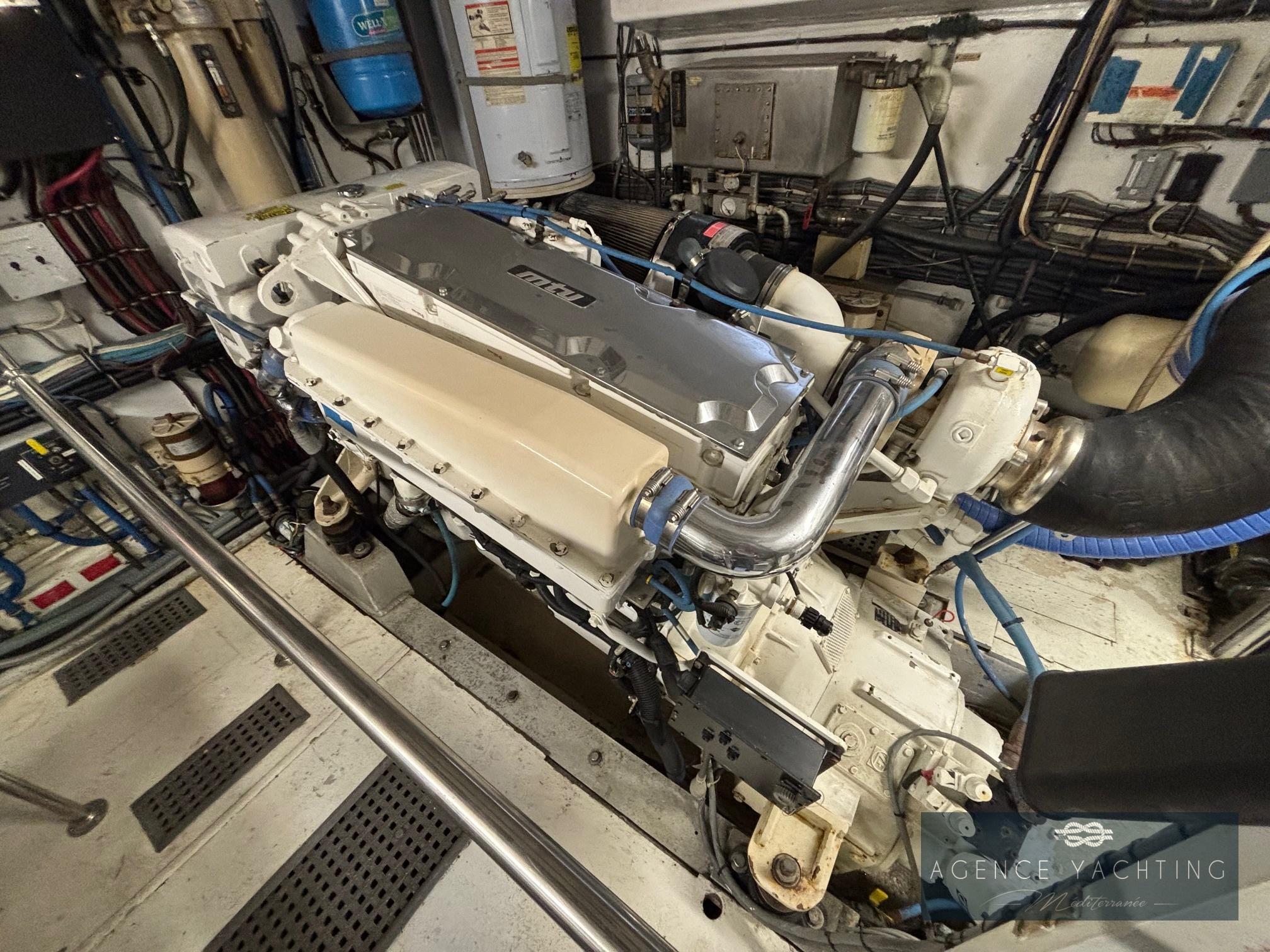 Engine room of a 1987 Hatteras 85 yacht, showcasing detailed machinery and components.