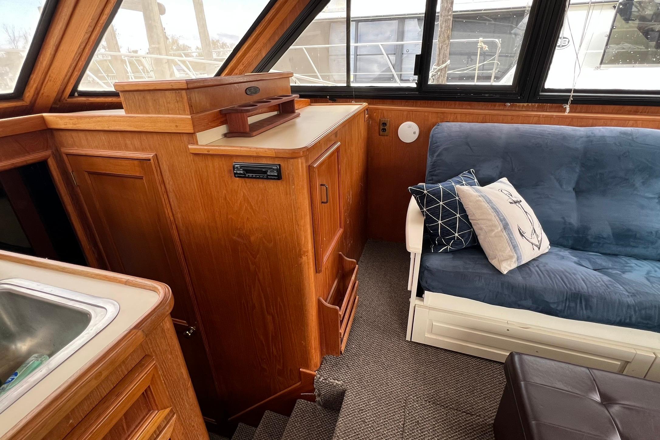 1989 Egg Harbor 33 Convertible interior with wooden cabinetry and blue cushioned seating.