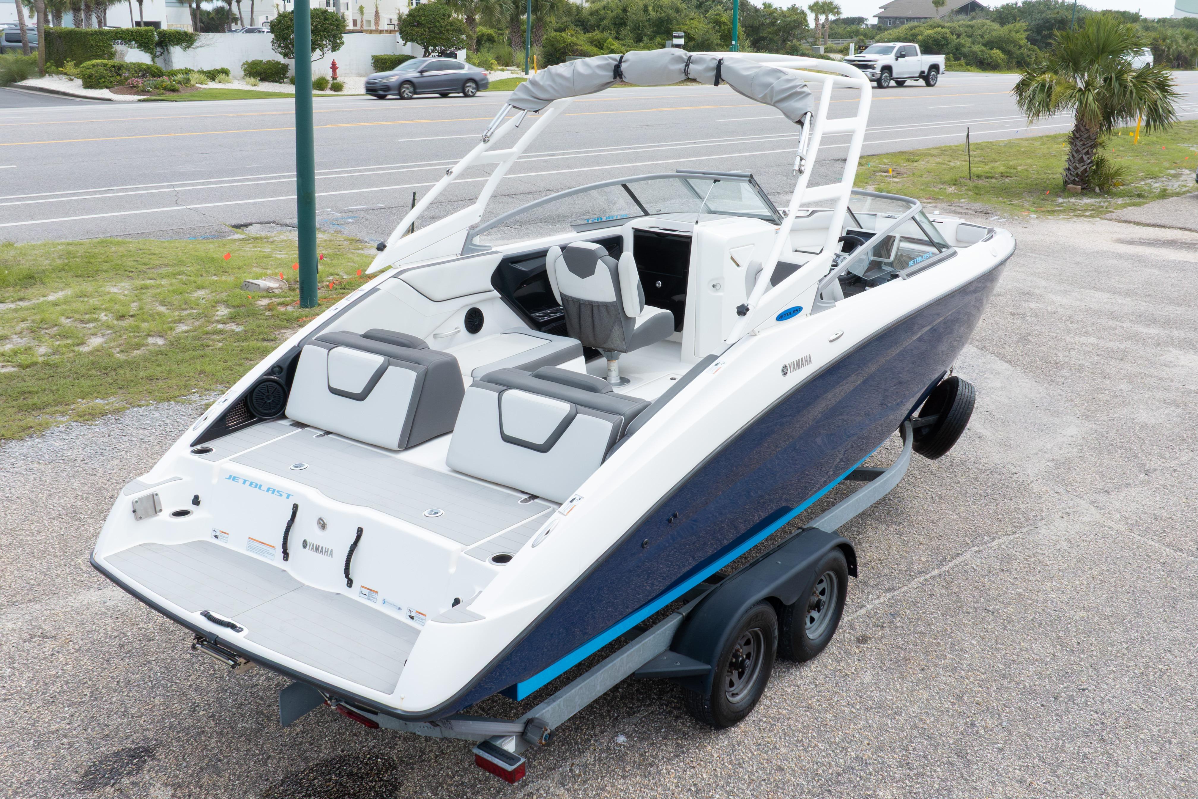 2021 Yamaha Boats AR250 on trailer, parked near a road, showcasing sleek design.
