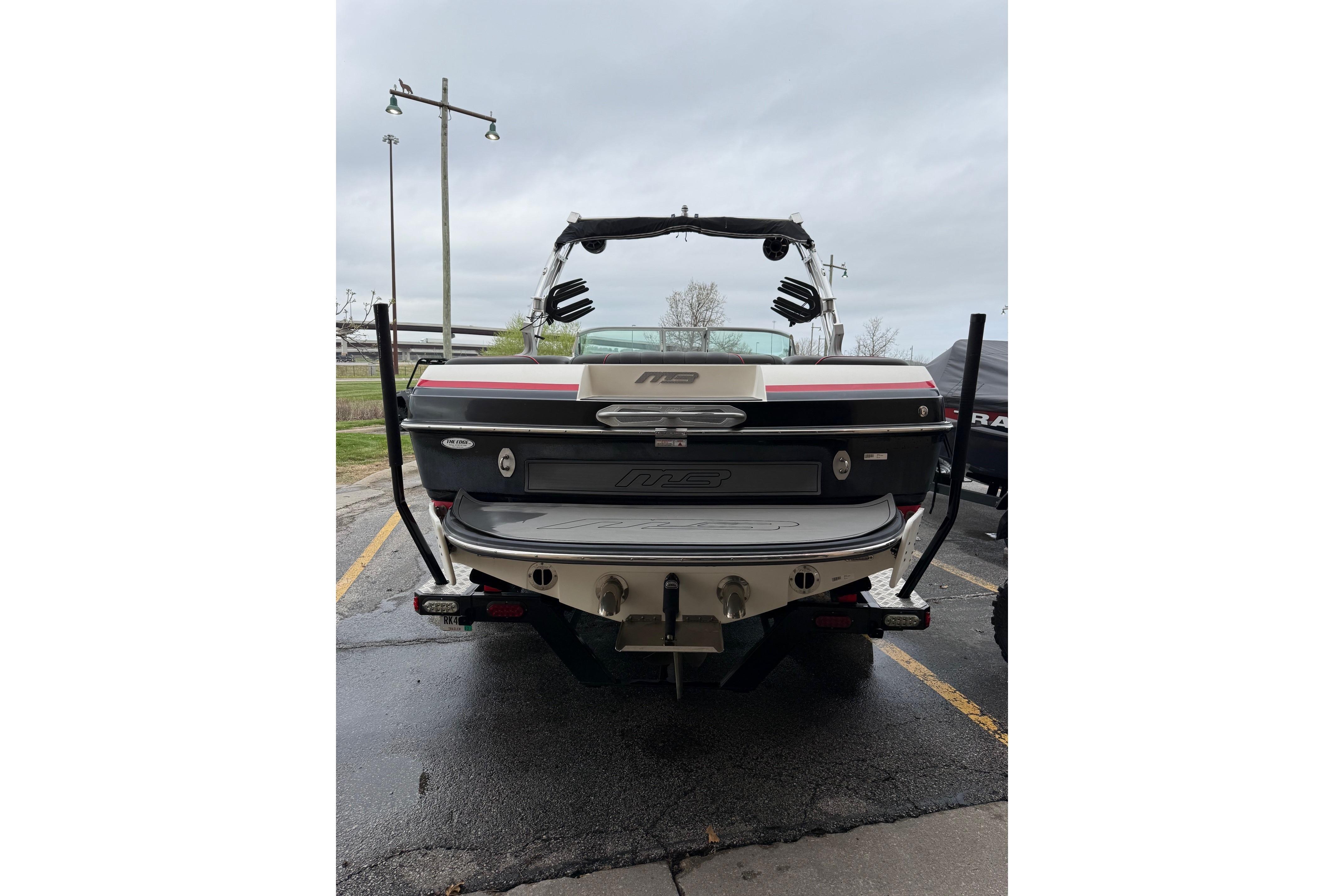 2014 MBSPORTS B523 23V boat, rear view, parked on wet pavement.