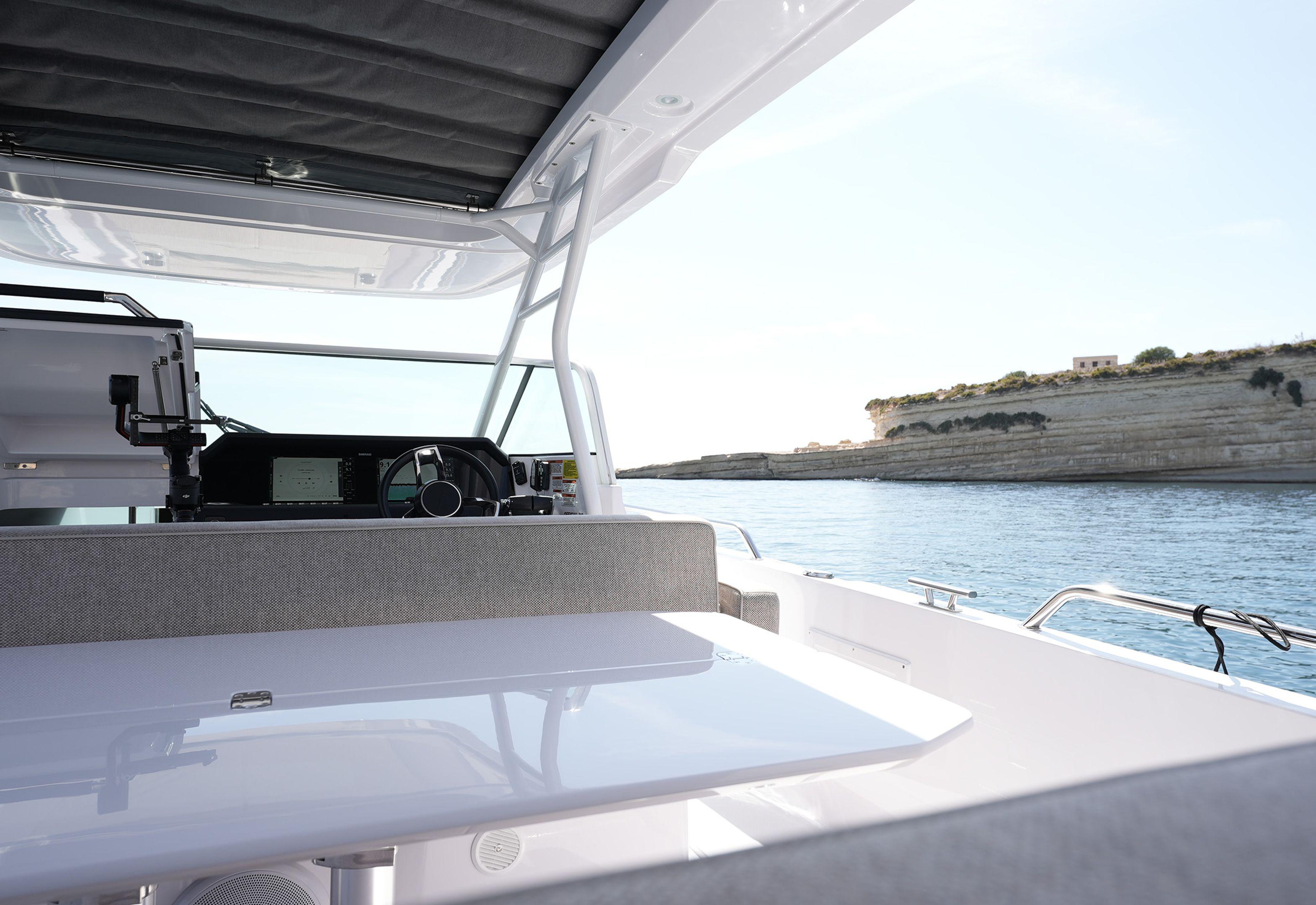 2023 Axopar 37 Sun Top boat interior with helm, table, and scenic water view.