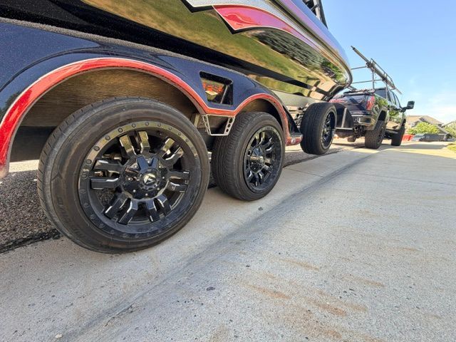 Close-up of a boat trailer with black rims, towed by a vehicle.