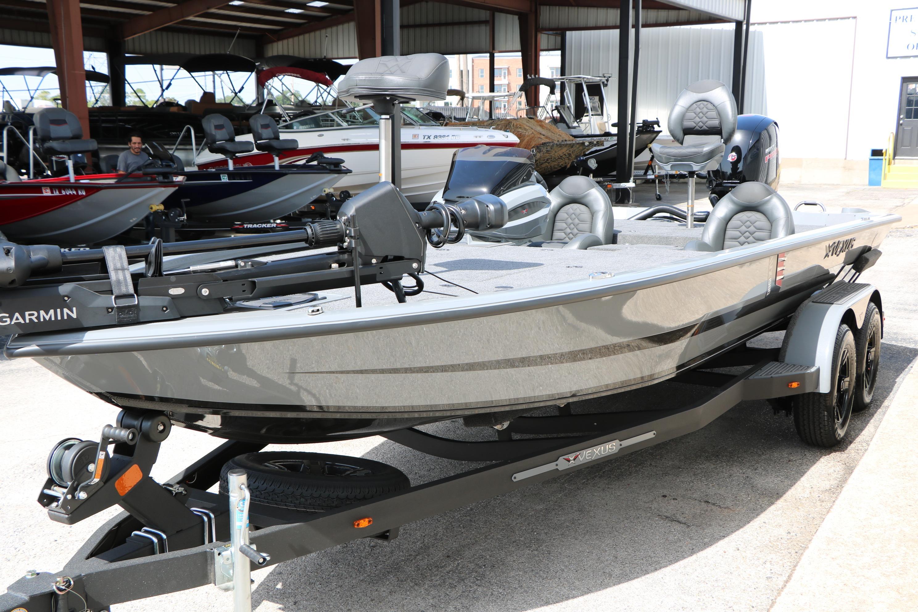 2026 Vexus AVX1980 boat on trailer, featuring Garmin equipment, in a showroom setting.