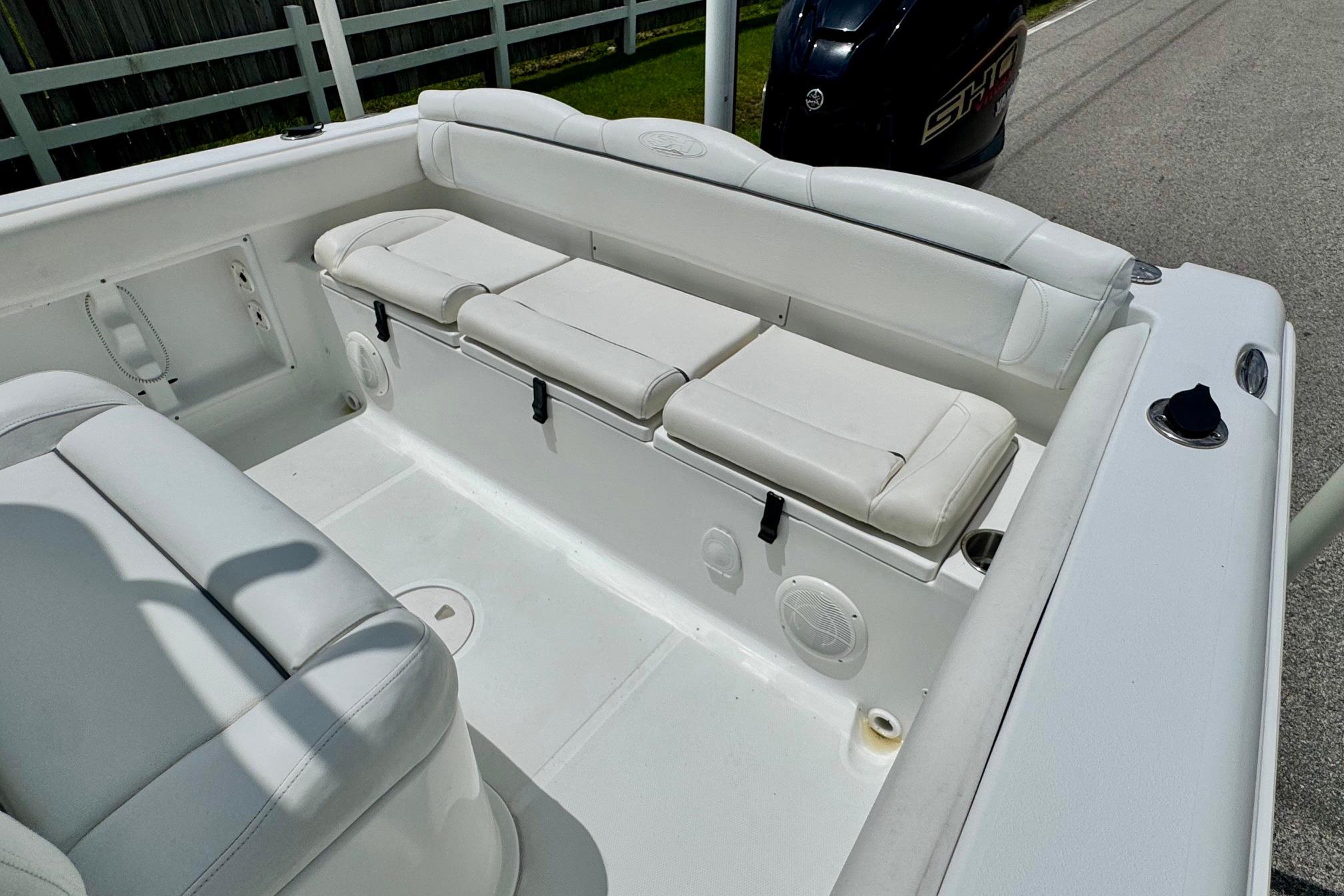 2015 Sea Hunt Ultra 234 boat interior with white cushioned seating and storage.