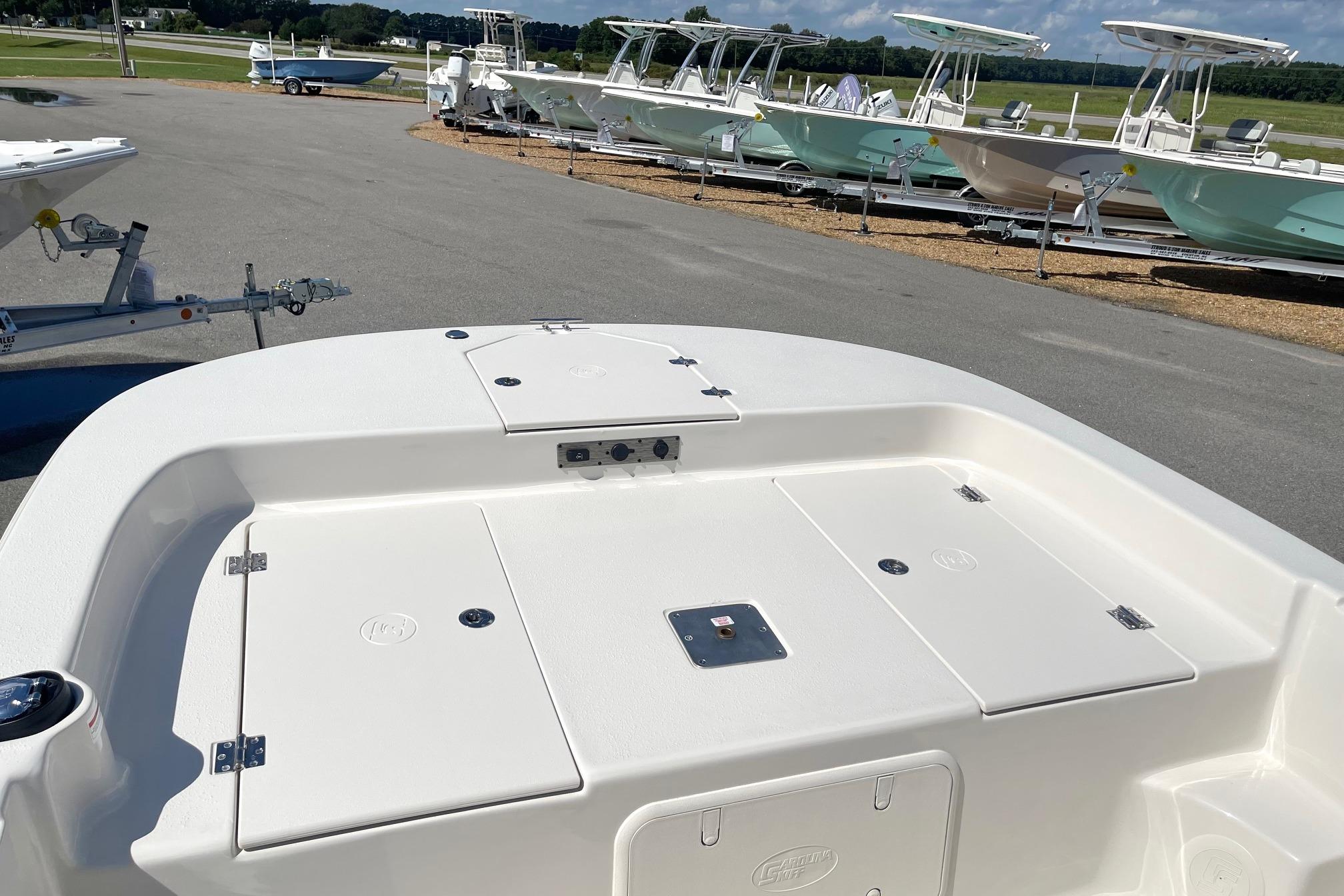 2026 Carolina Skiff 19 LS boat deck, white finish, parked with other boats.