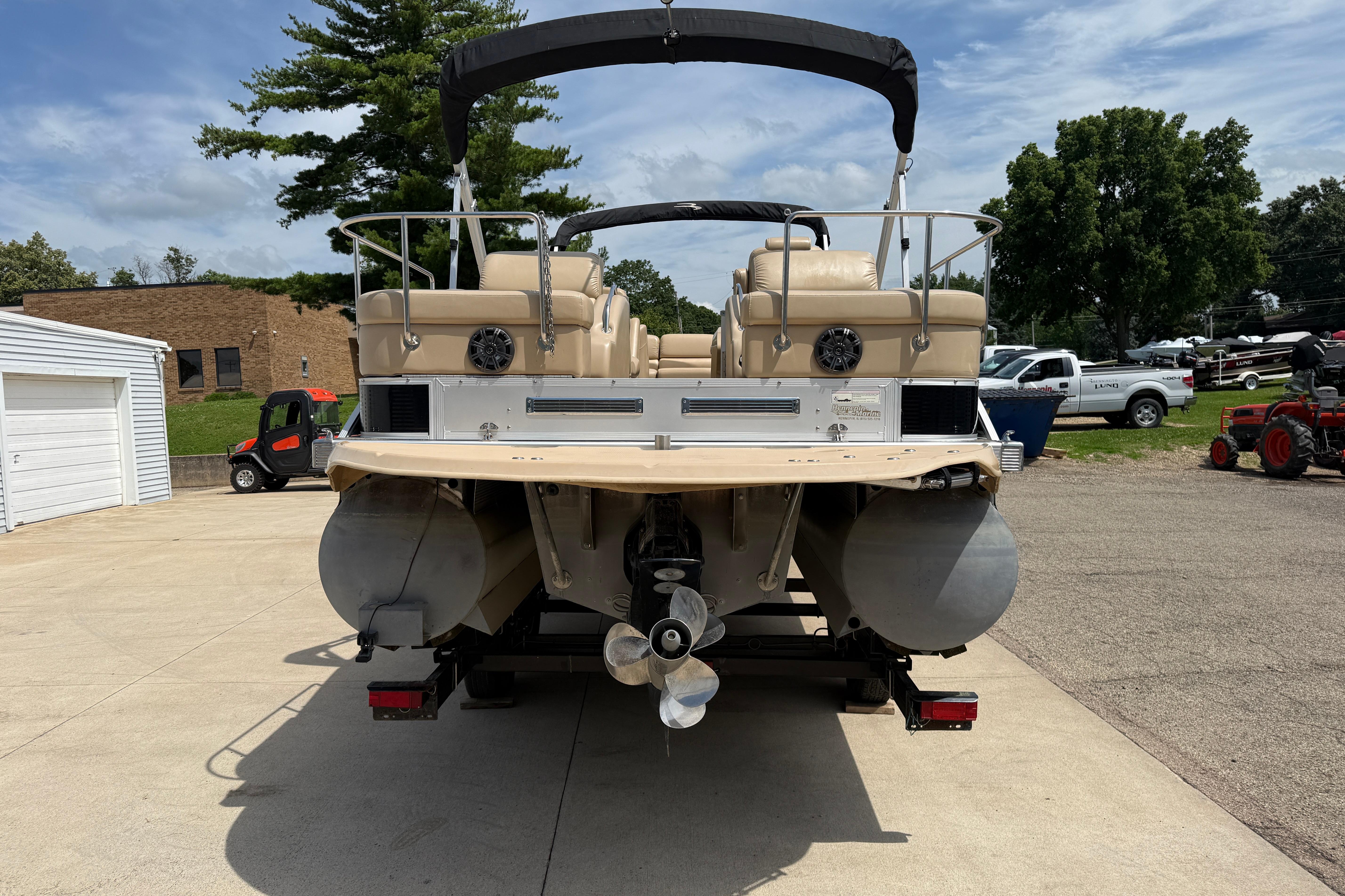 2011 Bennington 2575QCW I/O pontoon boat on trailer, parked outdoors.