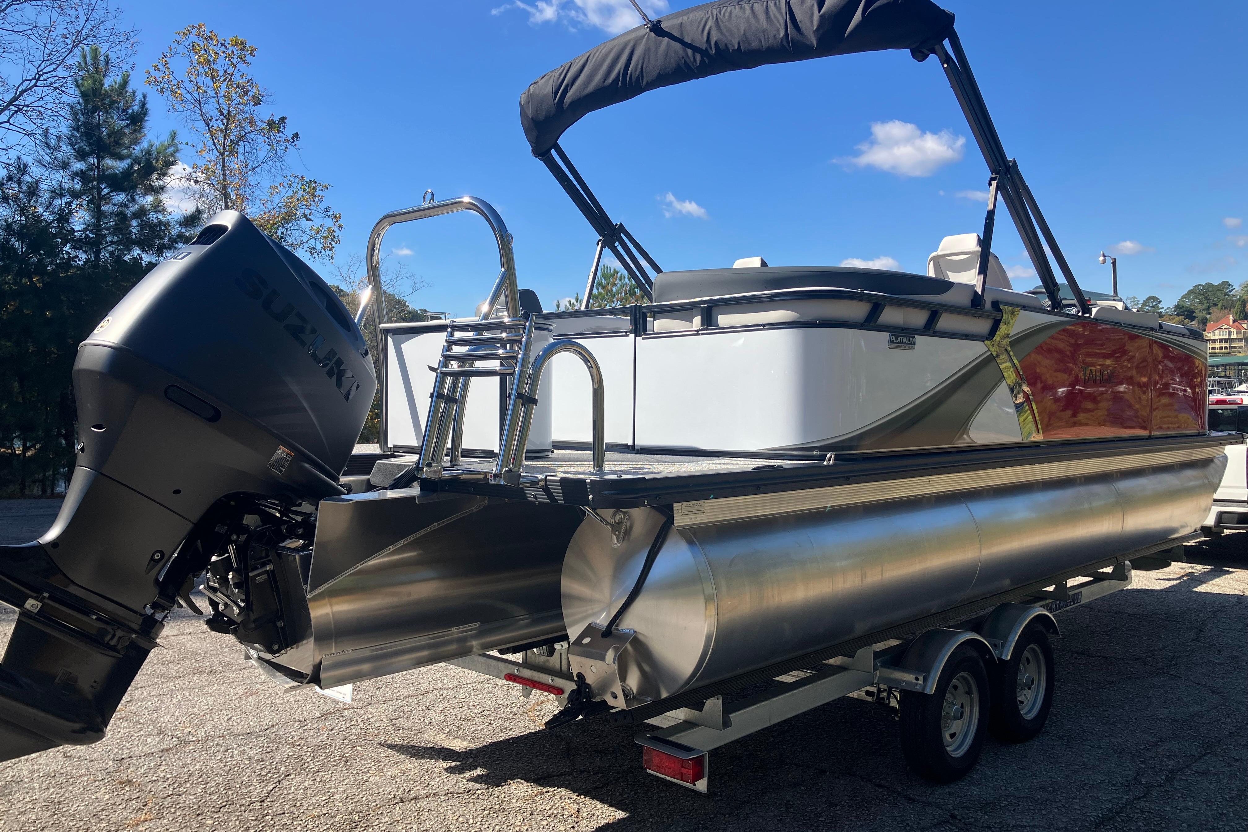 2026 Tahoe Pontoon LTZ Quad Lounger on trailer, featuring Suzuki outboard motor.