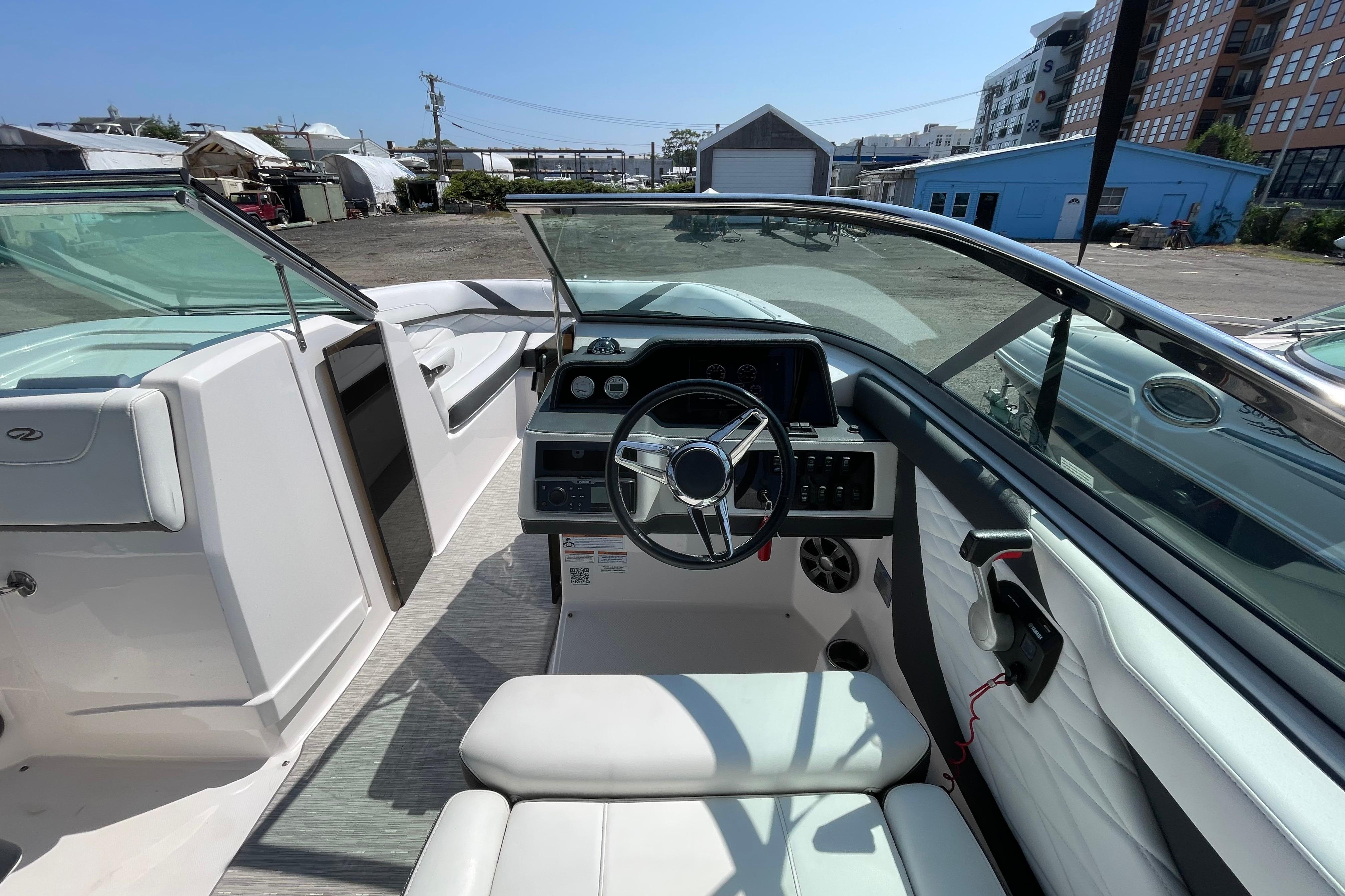 2018 Regal 26 OBX boat interior with steering wheel and seating, docked outdoors.