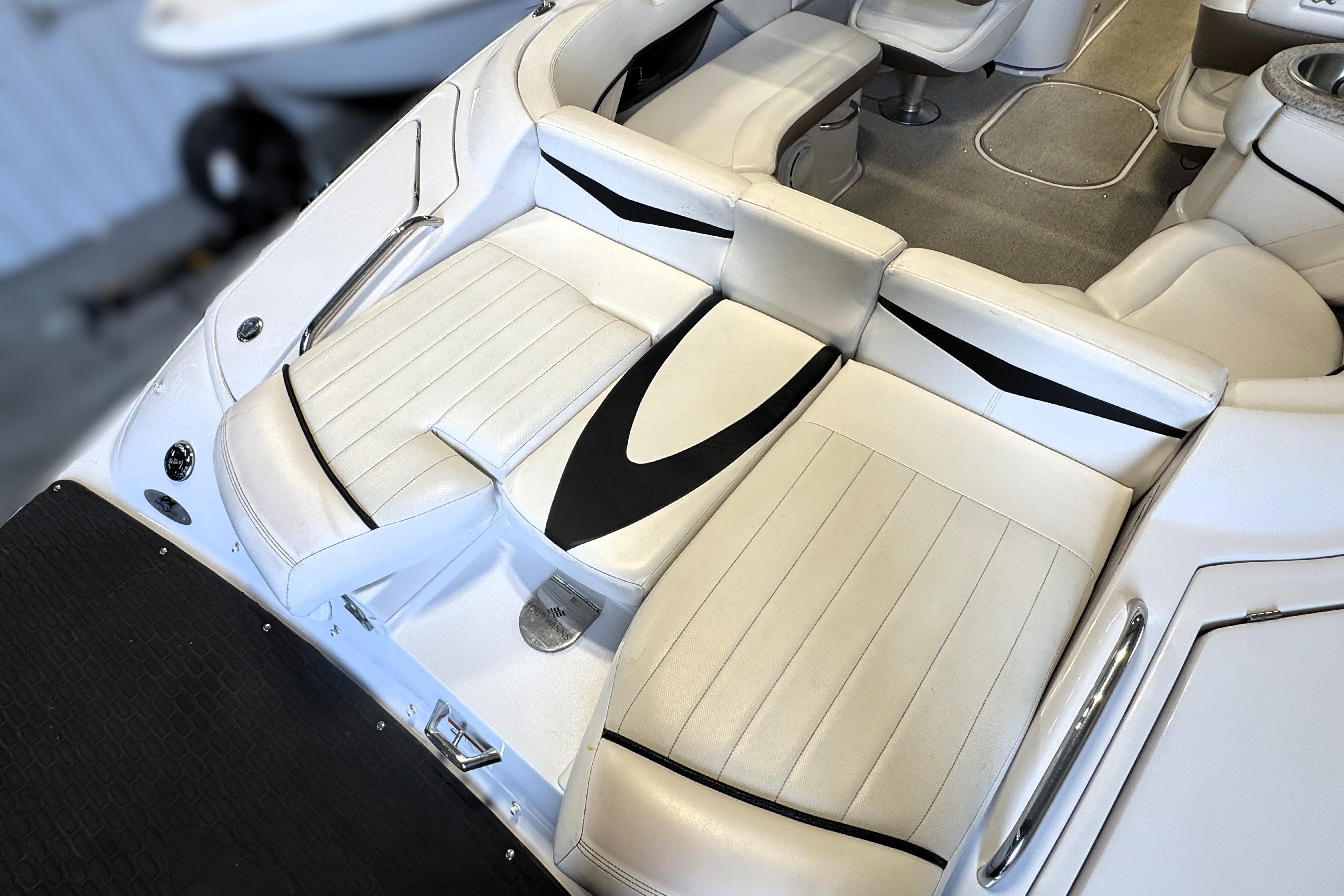 Interior seating of a 2008 Four Winns H240 boat, featuring white and black upholstery.