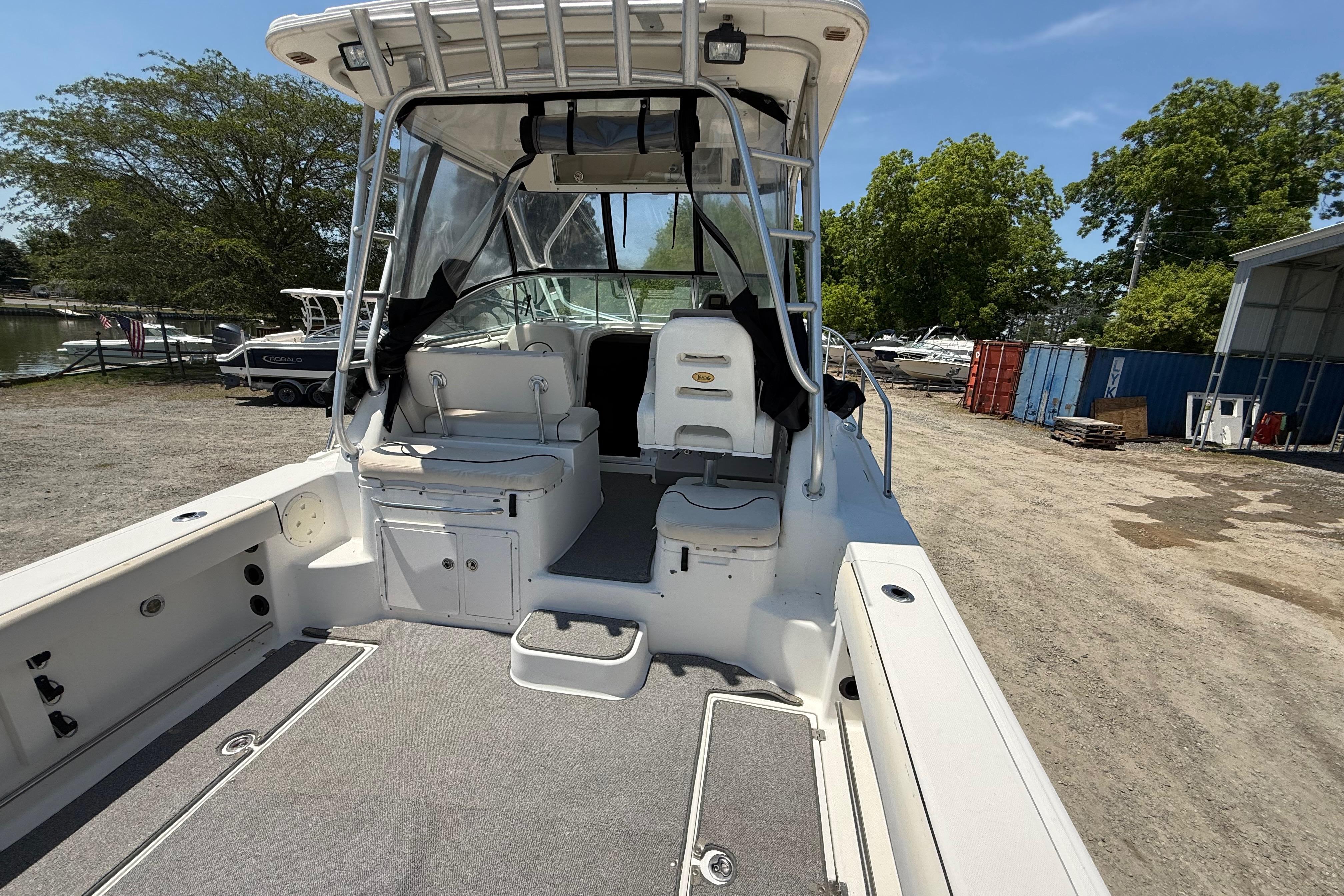 2007 Robalo R305 Walkaround boat interior with seating and storage, docked outdoors.
