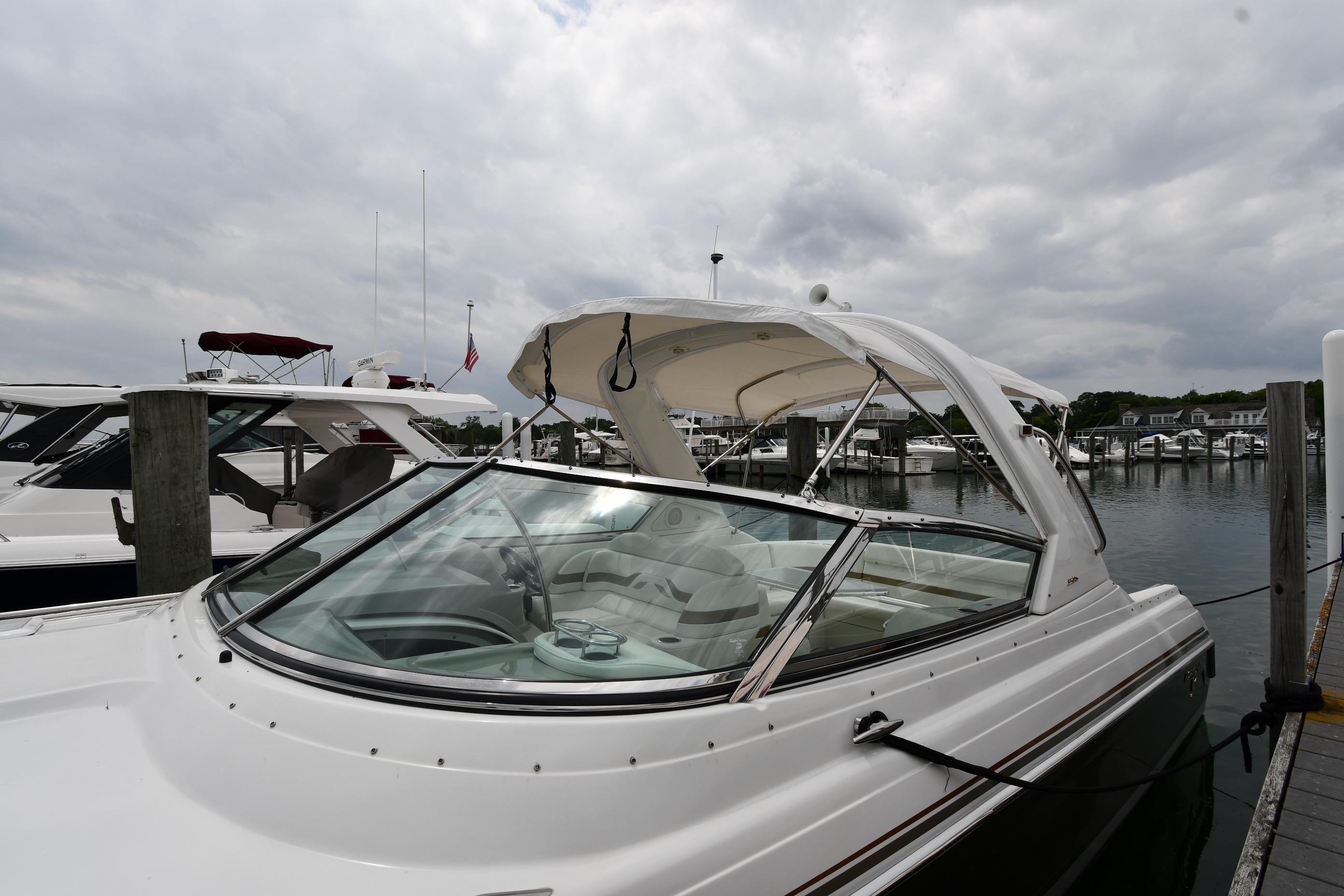 2004 Formula 330 Sun Sport boat docked at marina under cloudy sky.