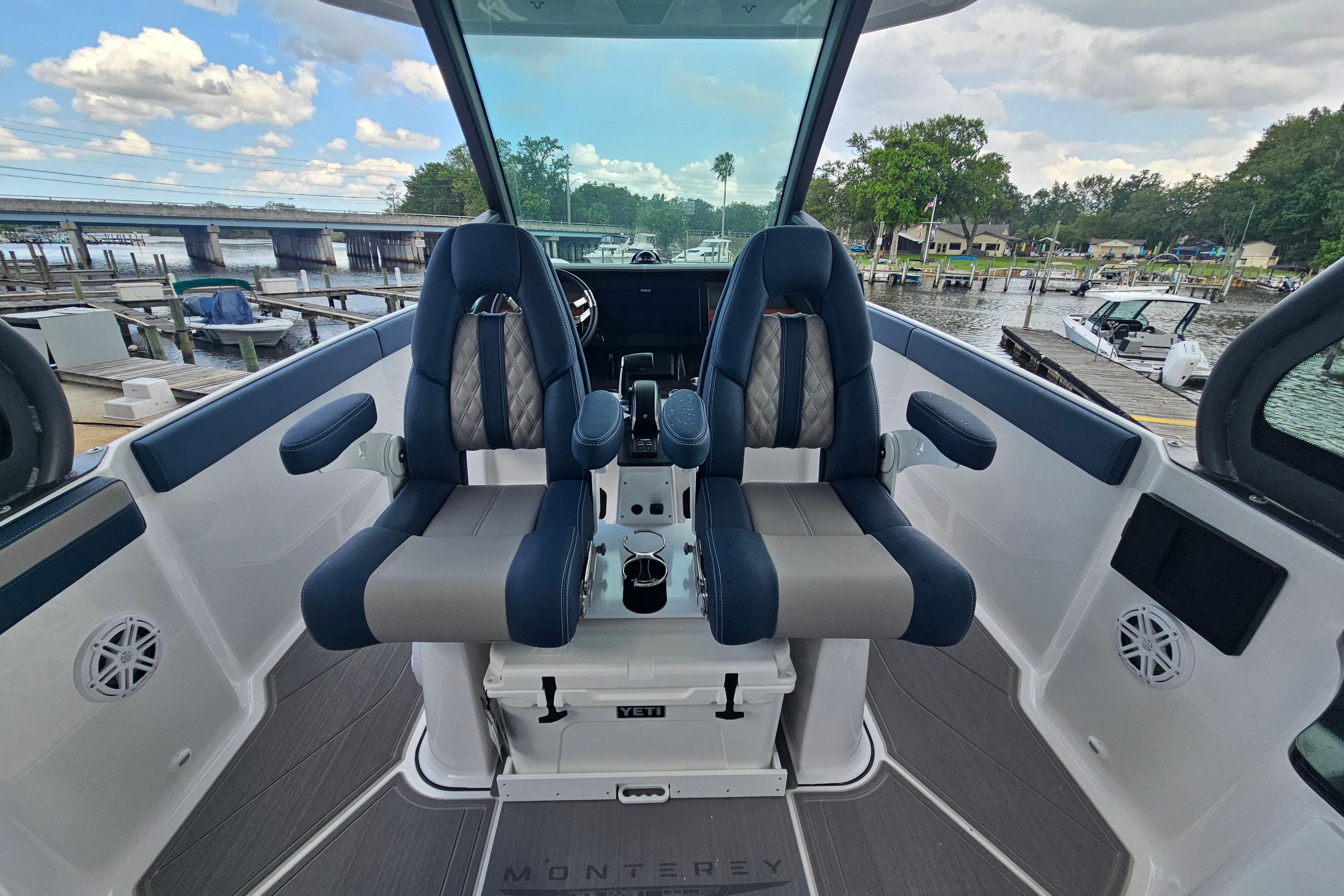 2026 Monterey Elite 27 OB boat interior with dual captain seats, dockside view.