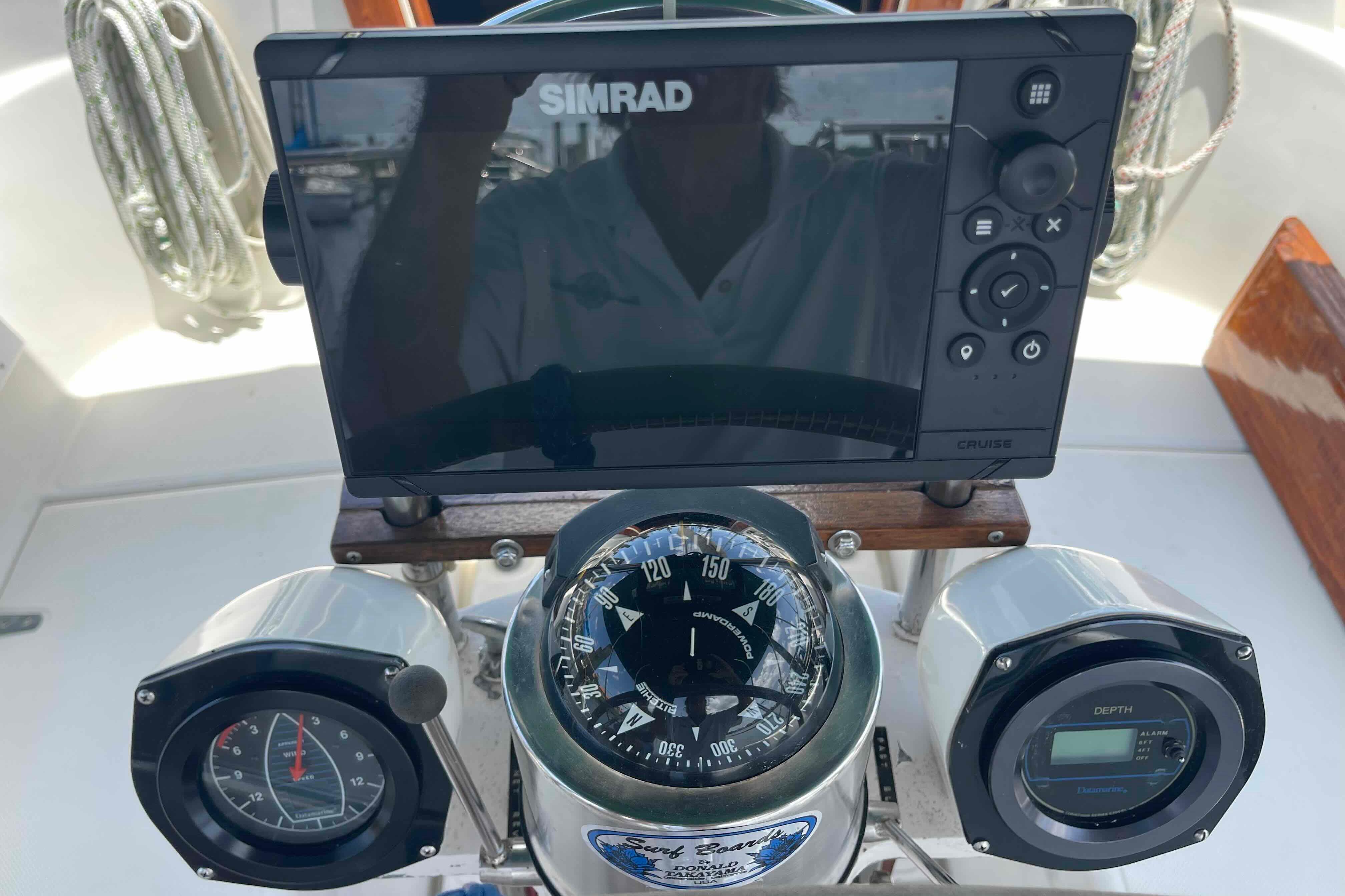Cockpit instruments of a 1987 Pacific Seacraft 34, featuring a Simrad display and compass.