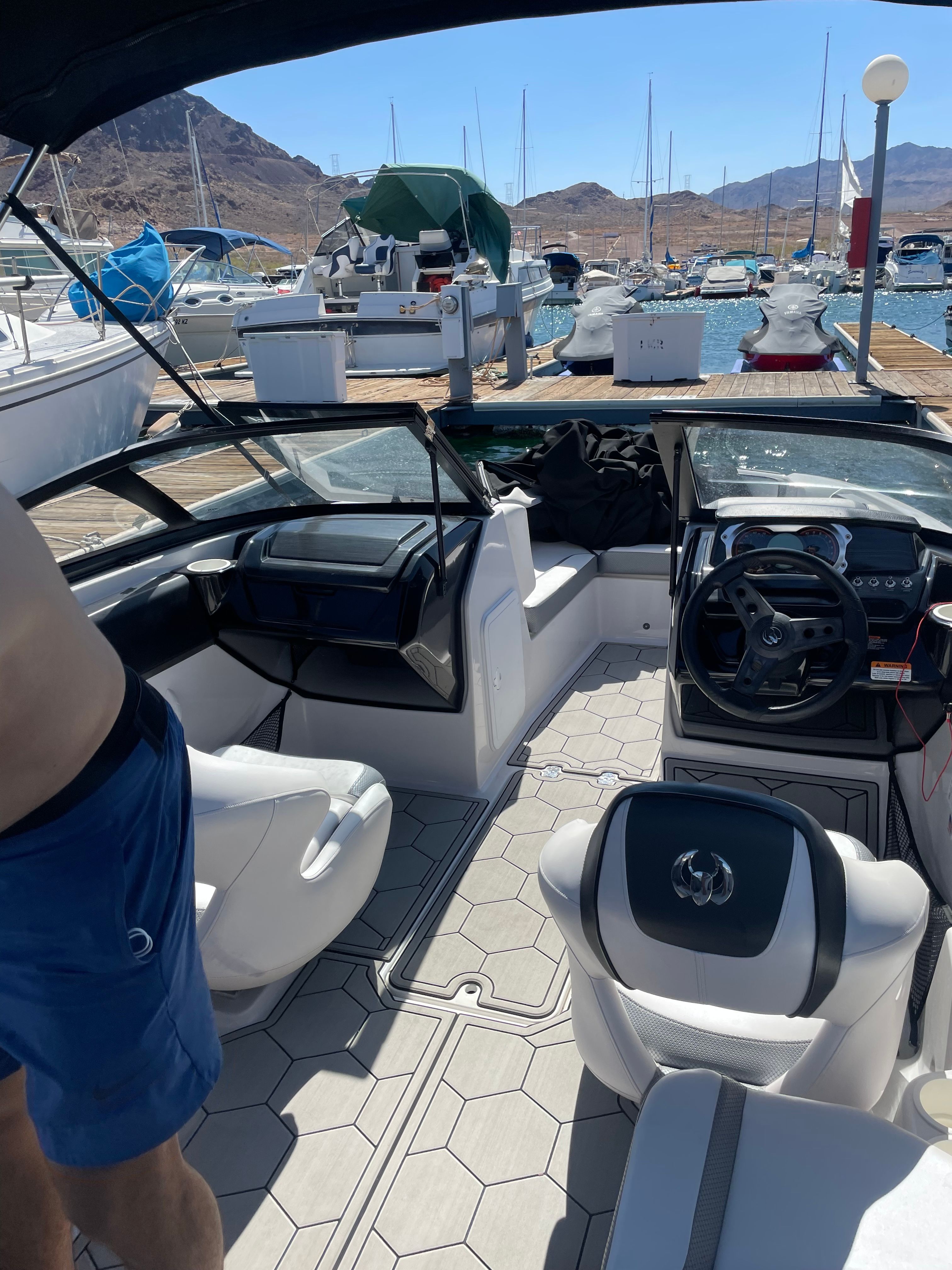 The image shows the cockpit of a 2019 Scarab 195 G boat docked at a marina.