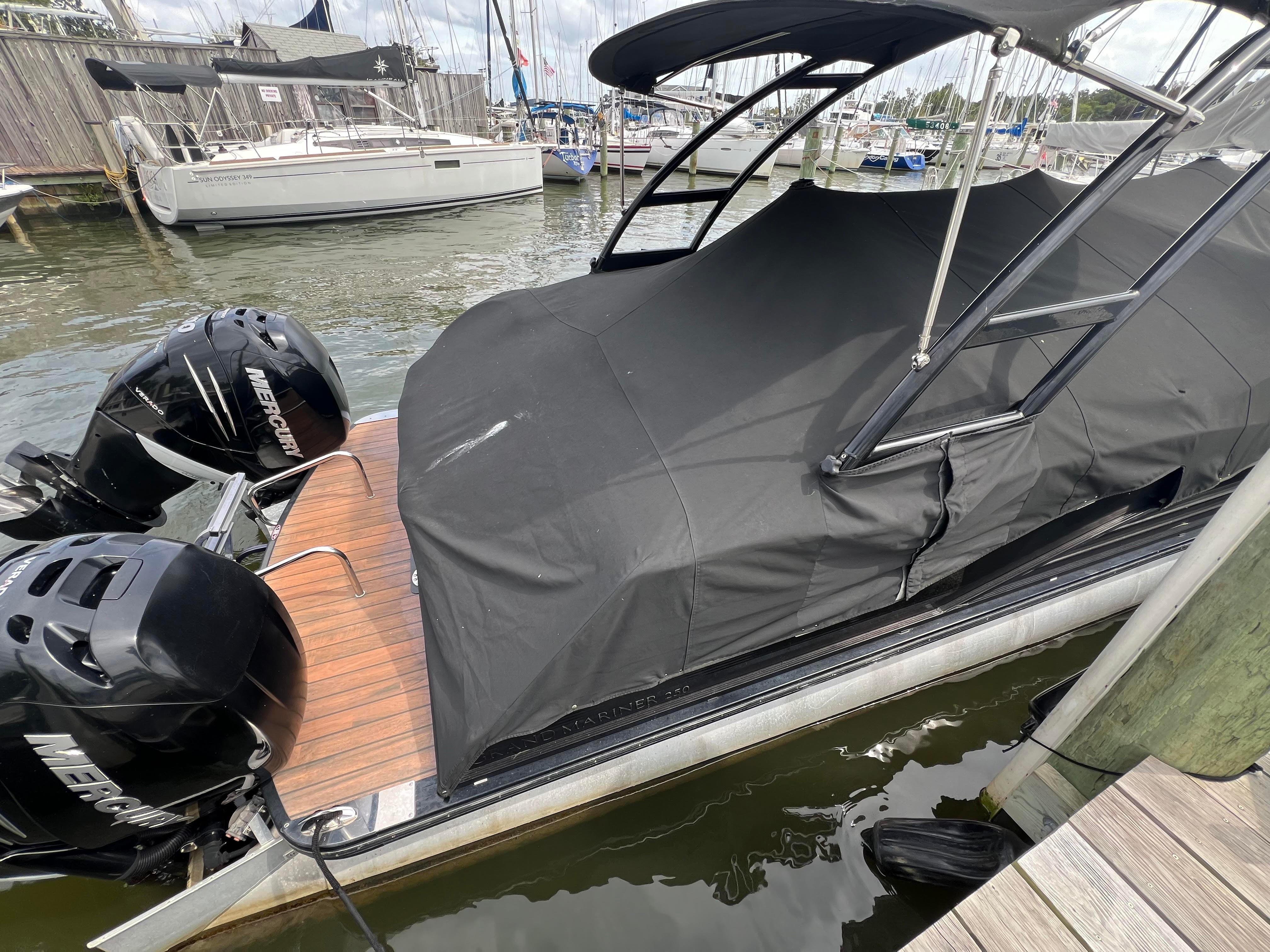 2015 Harris FloteBote Grand Mariner SL 250 with cover at dock.