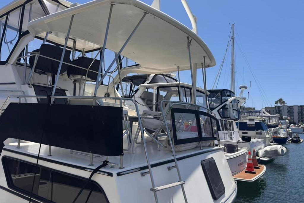 1982 Sunliner Ocean Yachts docked in a marina under clear blue skies.