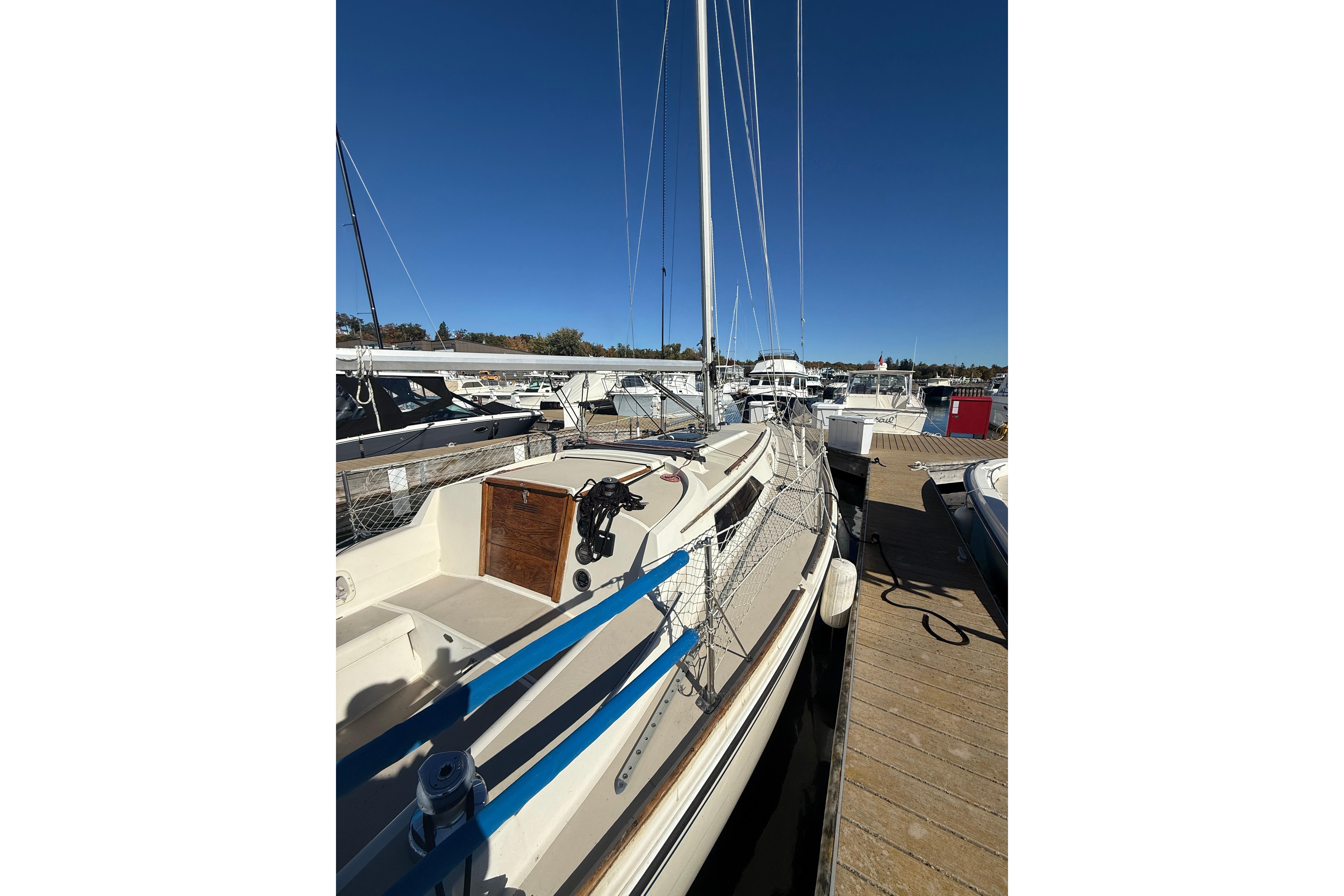 1983 O'Day 34 sailboat docked at marina under clear blue sky.