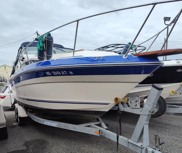 1988 Sea Ray 268 DA boat on trailer, blue and white design, parked outdoors.