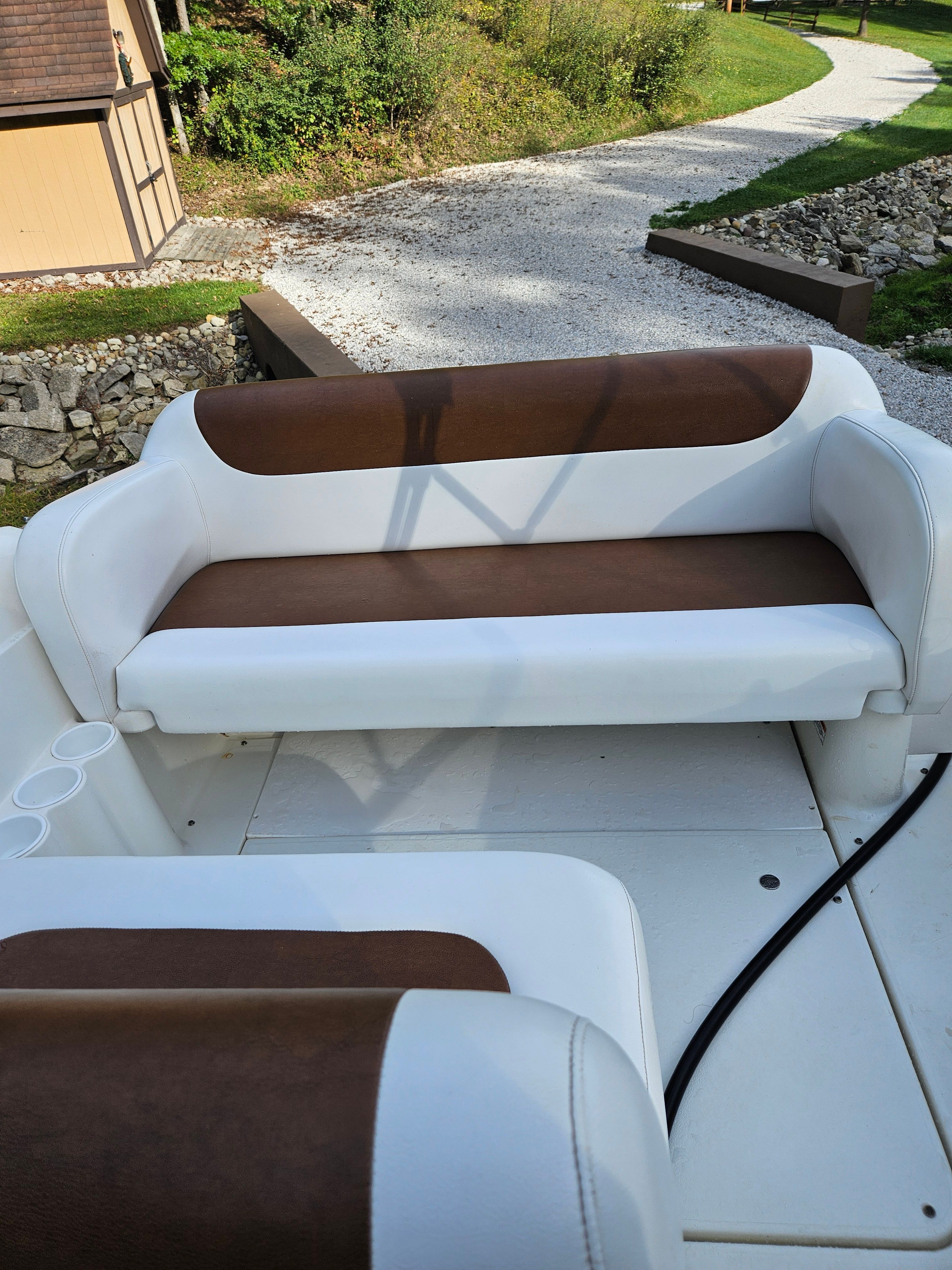 Interior of a 1998 Larson Cabrio 254 boat with brown and white seating.