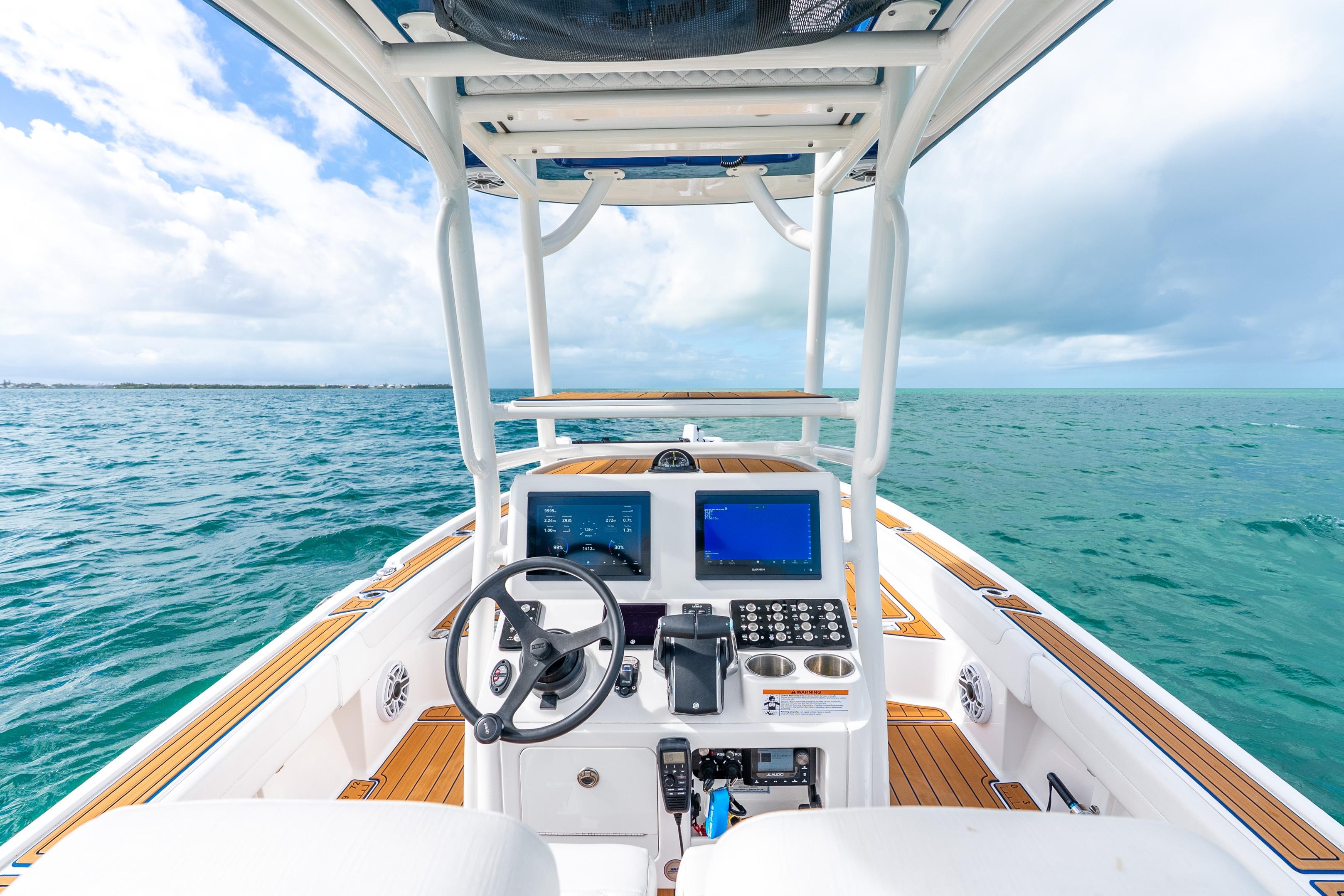 2024 Caymas 281 HB boat dashboard with ocean view, featuring modern controls and navigation screens.