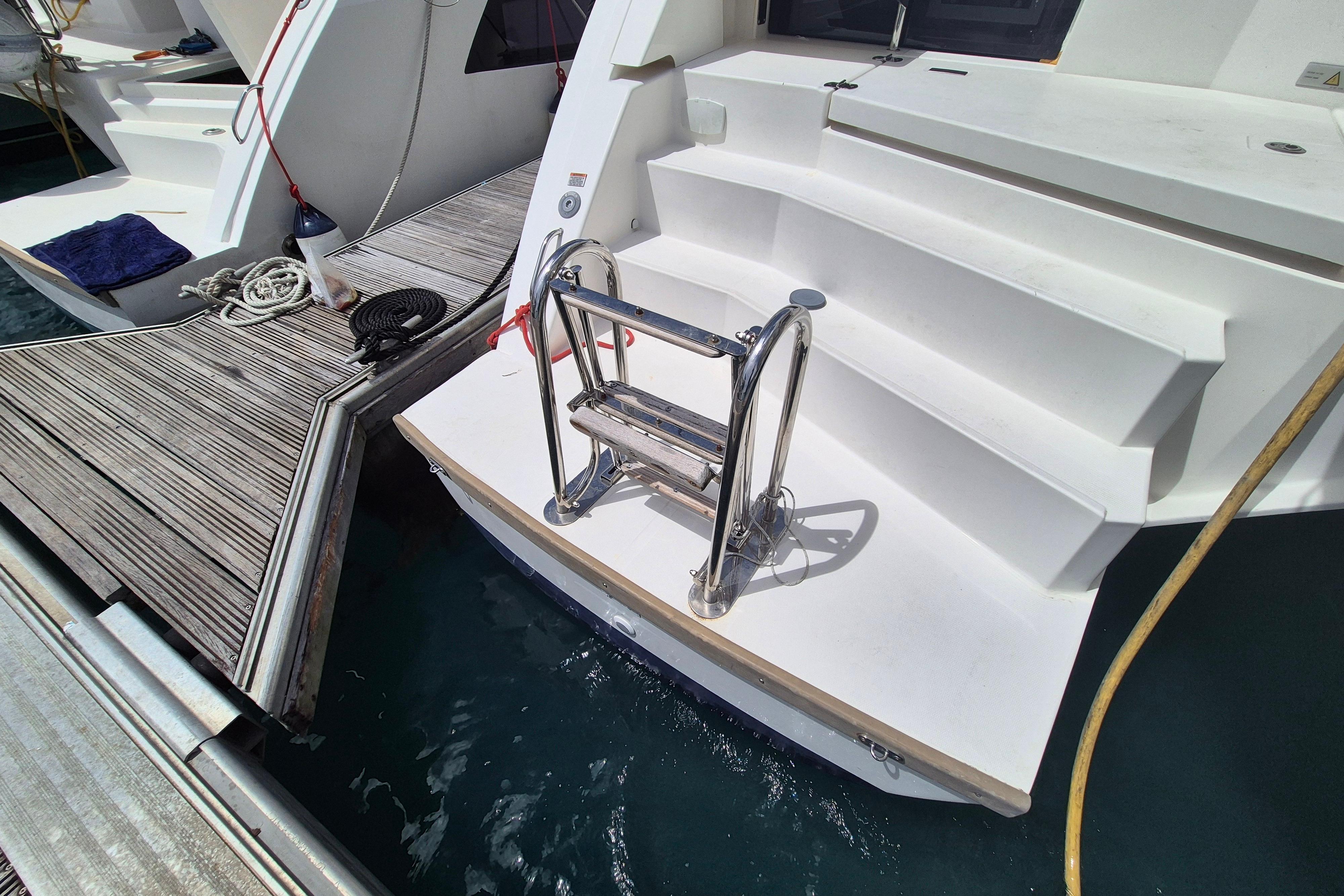 Boarding platform and ladder on a 2021 Leopard 50 yacht, docked at a marina.