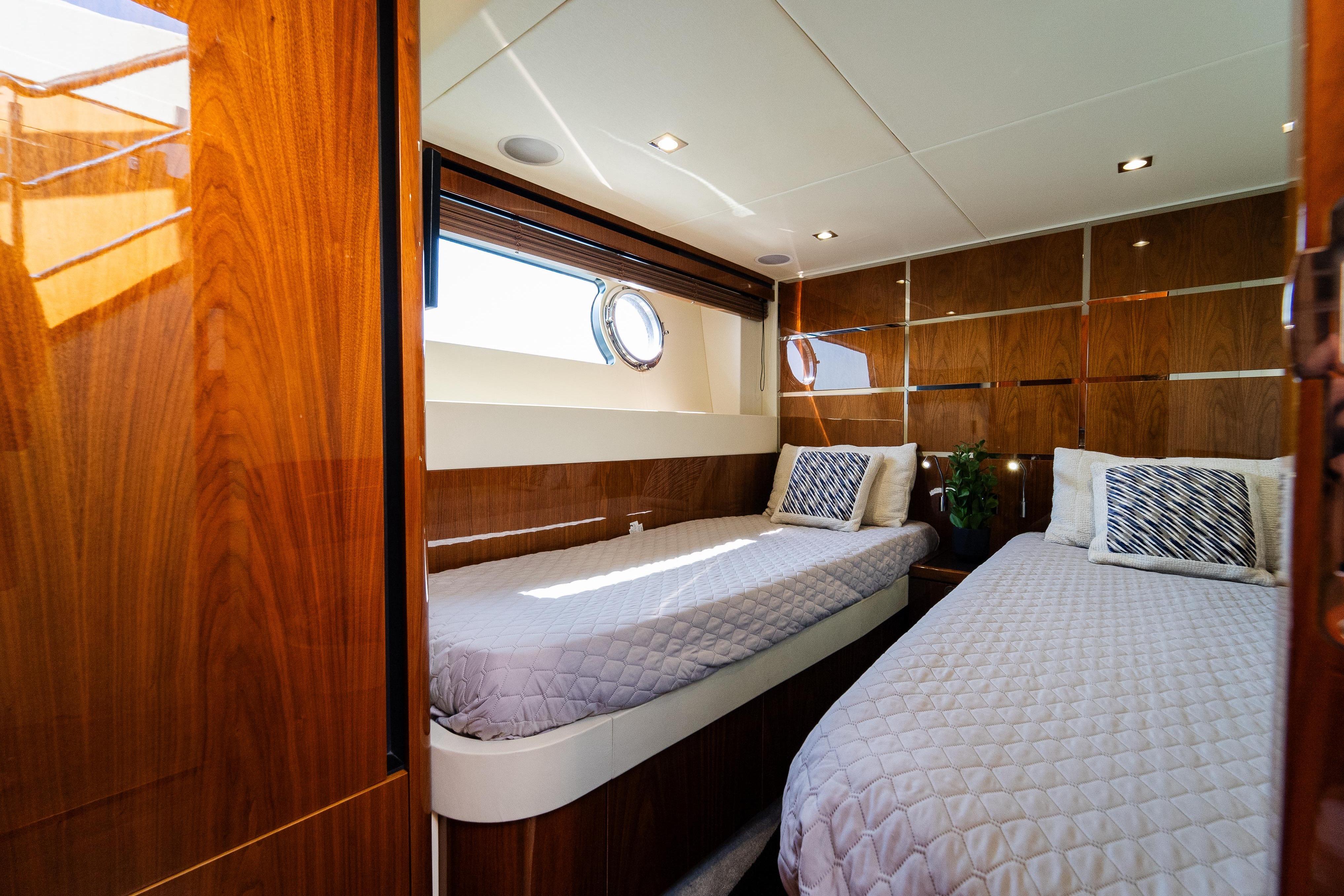Luxurious twin cabin interior of 2016 Sunseeker Manhattan 65 yacht with elegant wood paneling.