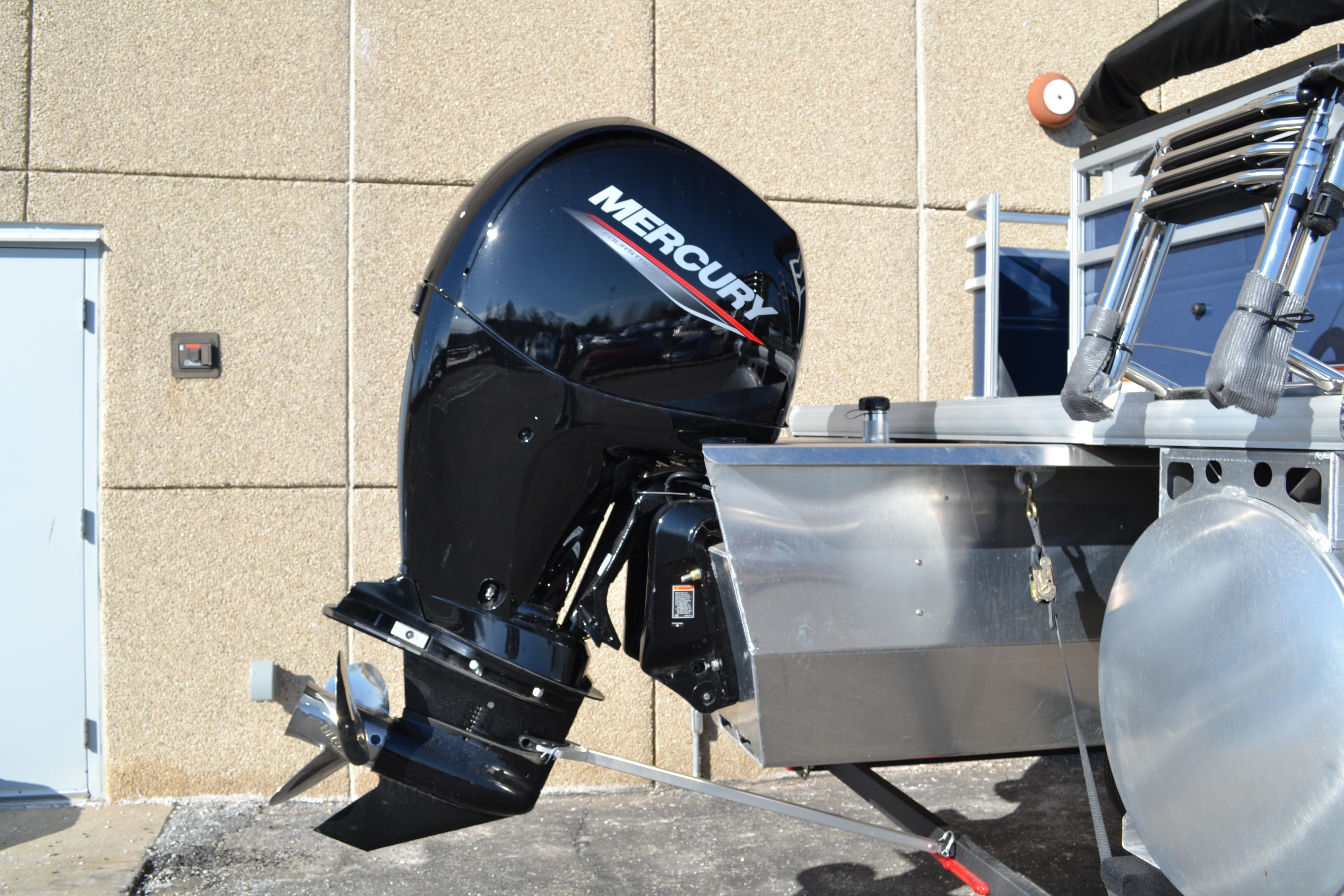 2026 Sun Tracker SportFish 22 XP3 with Mercury outboard motor, parked outdoors.