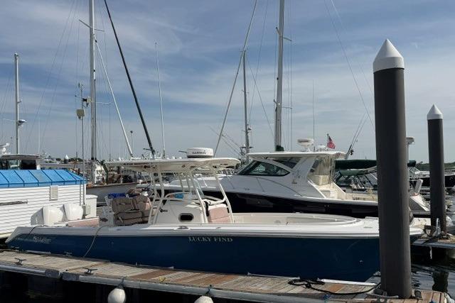 2014 Edgewater 318CC boat docked at a marina under a clear sky.