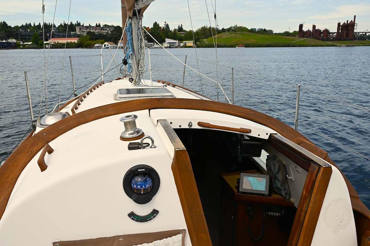 1977 Mercator Offshore sailboat on calm water, featuring wooden deck and navigation equipment.
