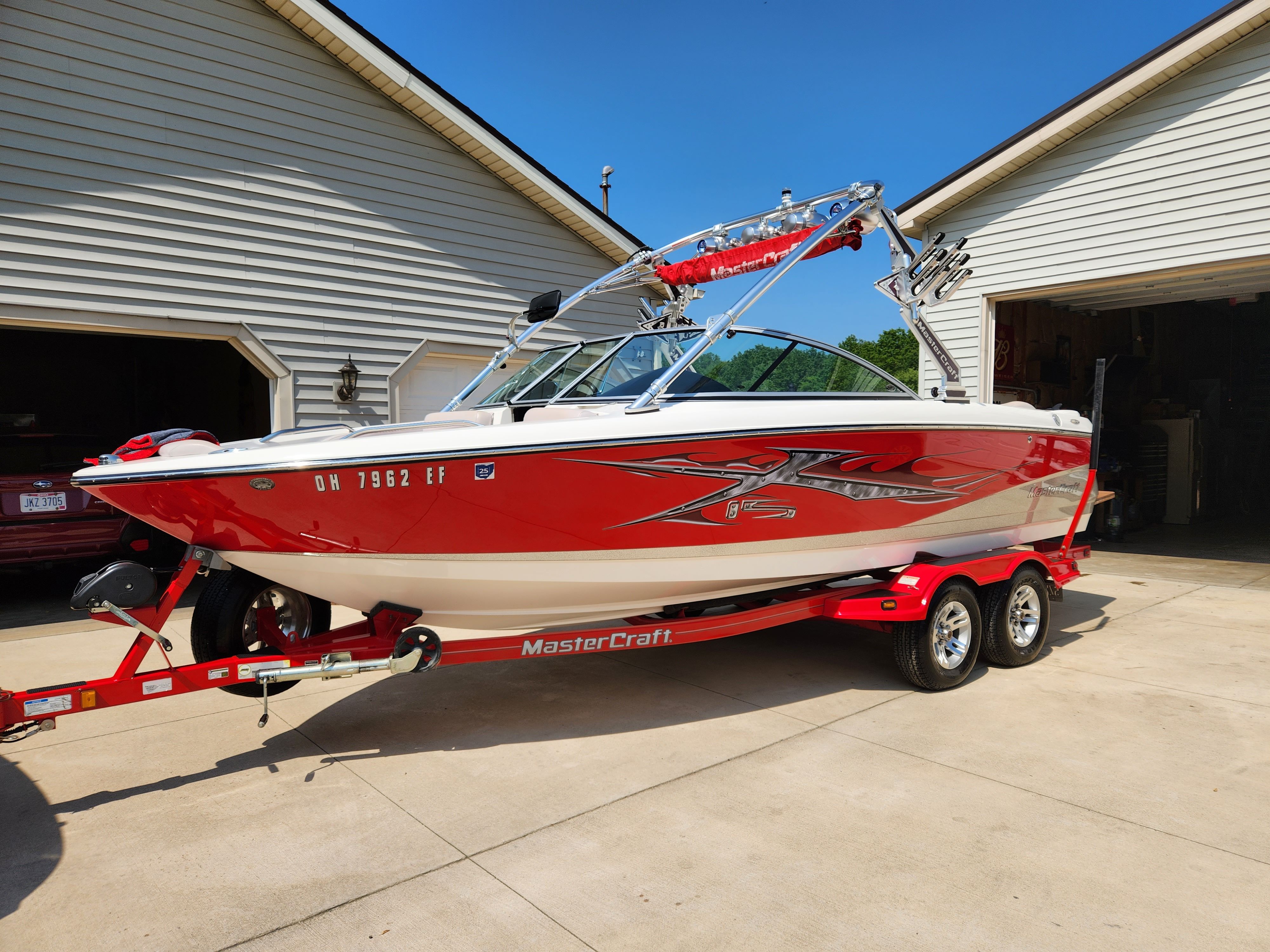 2007 MasterCraft X-15 boat on trailer in front of garage.