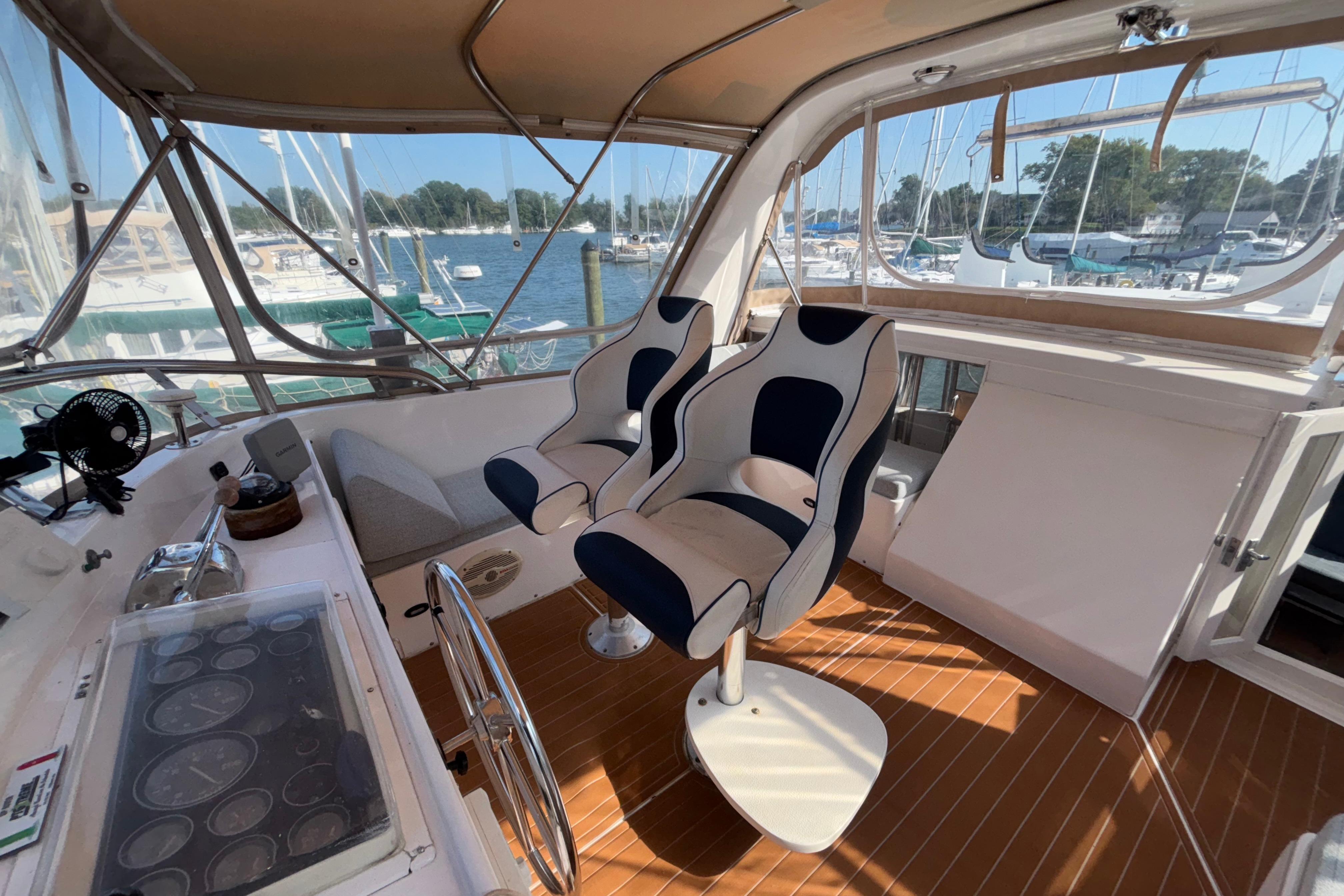 1989 Jefferson 42 Sundeck Motor Yacht helm with dual seats and marina view.