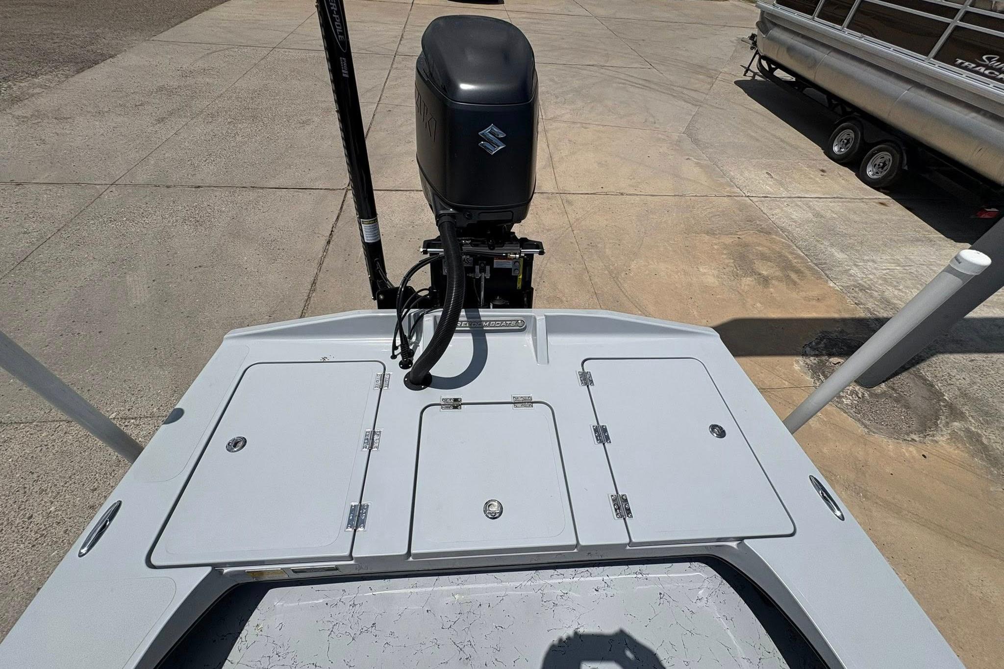 2026 Freedom Boats 23' Warrior with Suzuki outboard motor, docked on concrete surface.