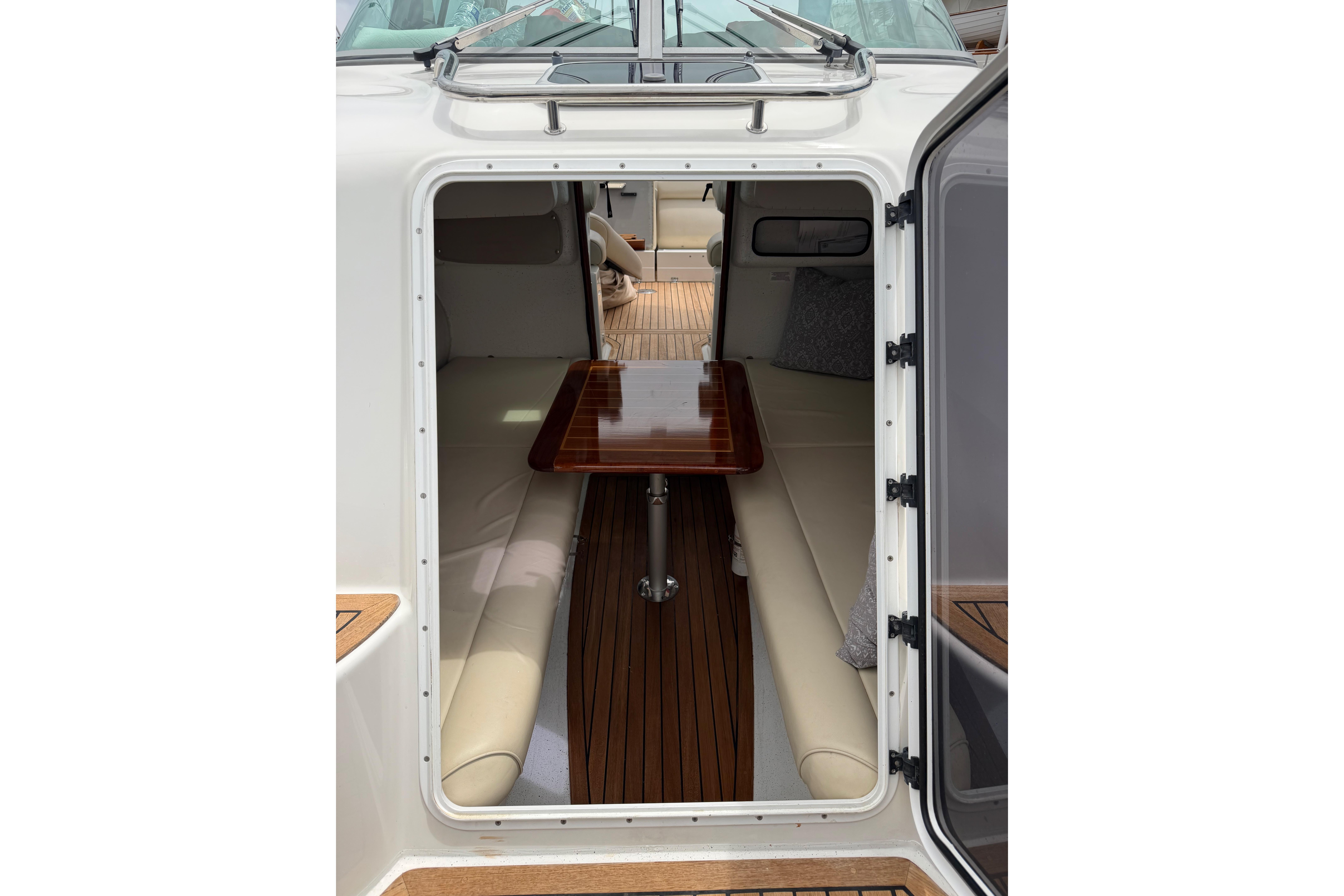 Interior view of 2016 Protector Targa 30 boat with wooden table and cushioned seating.