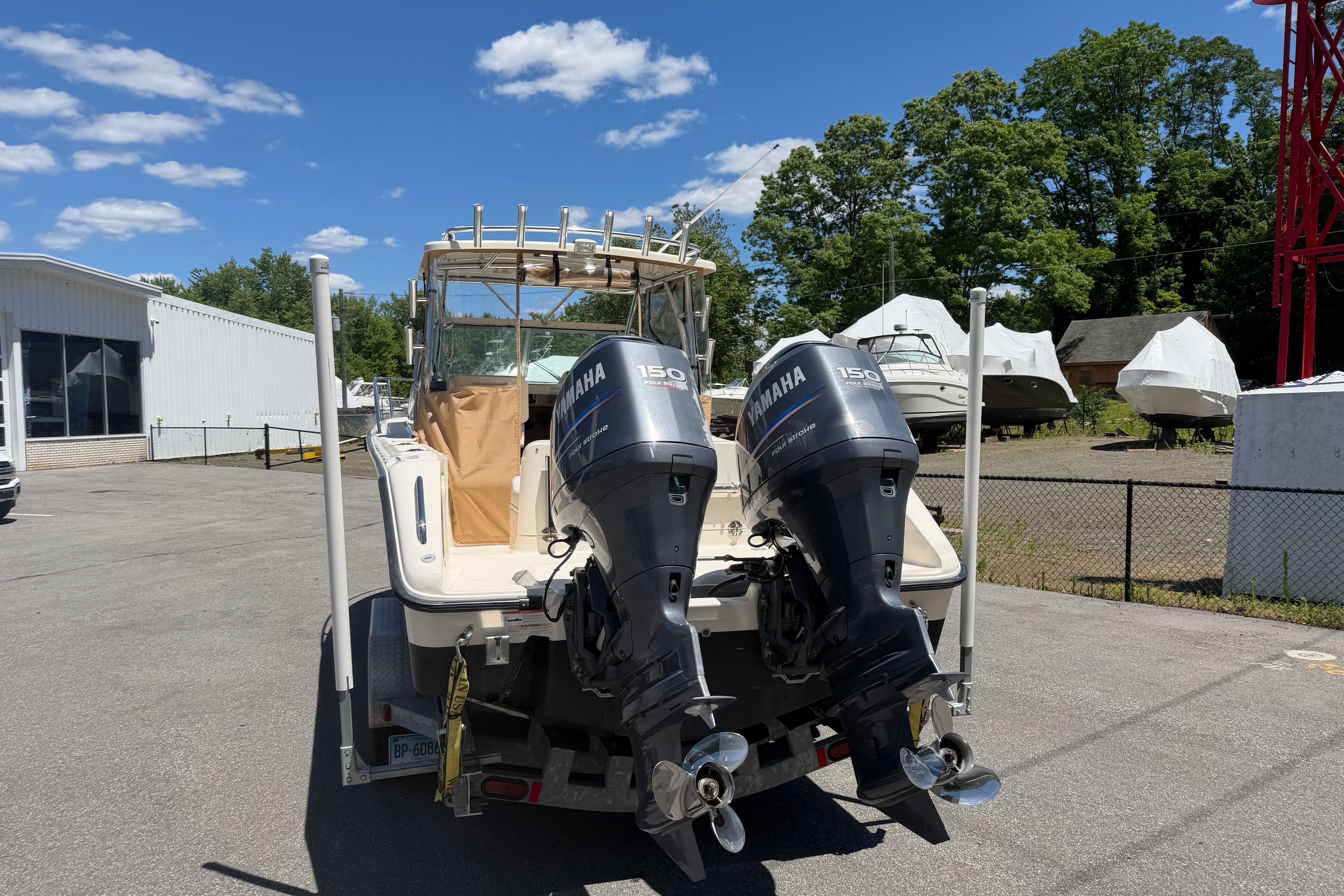 2010 Pursuit OS 255 Offshore boat with twin Yamaha 150 engines in a marina setting.