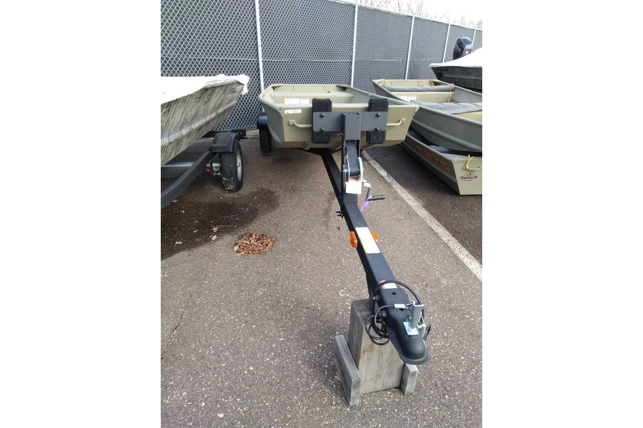 2026 Tracker Grizzly 14 Jon boat on trailer in parking lot.