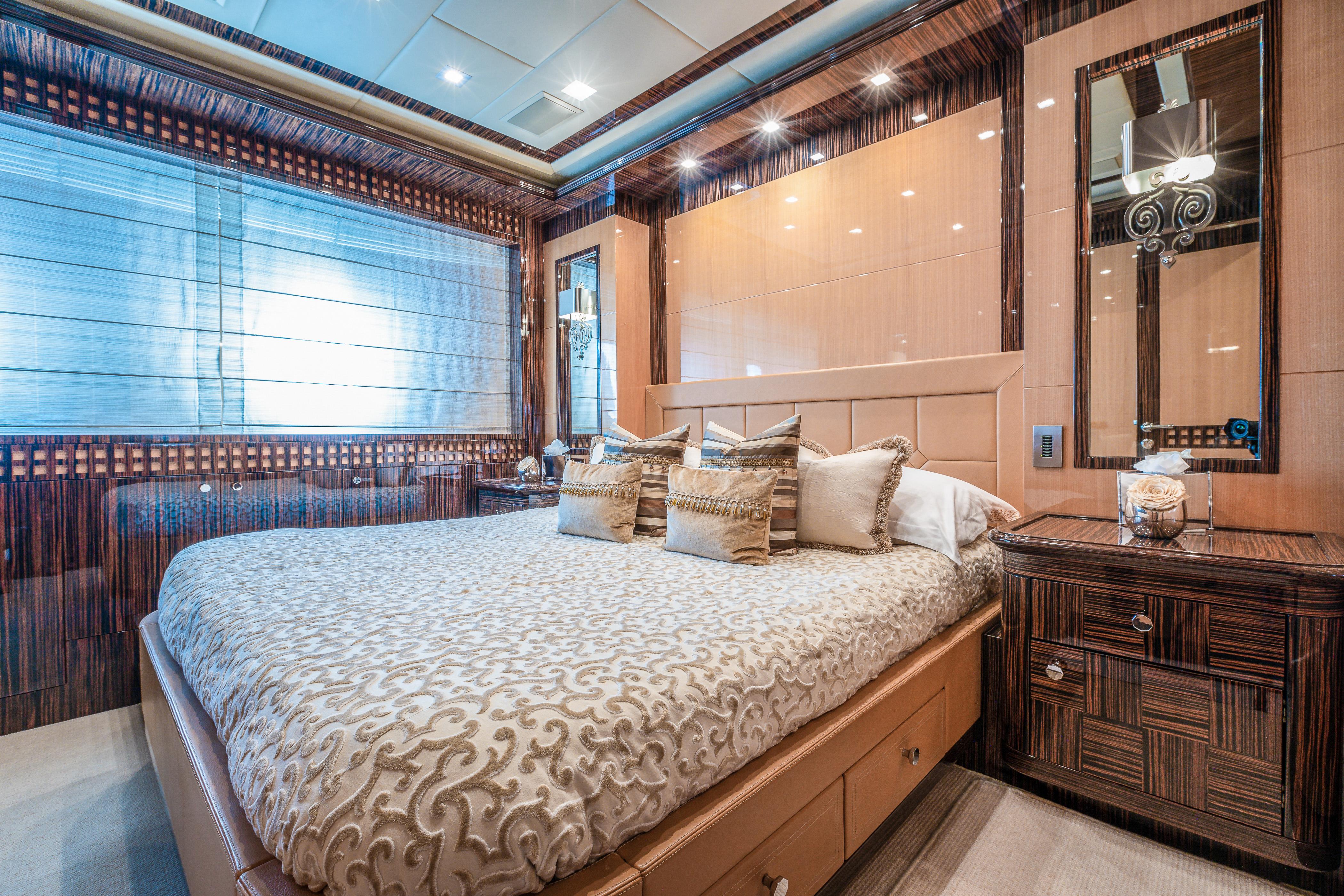 Luxurious bedroom interior on a 2011 Mangusta 165 yacht, featuring elegant decor and plush bedding.