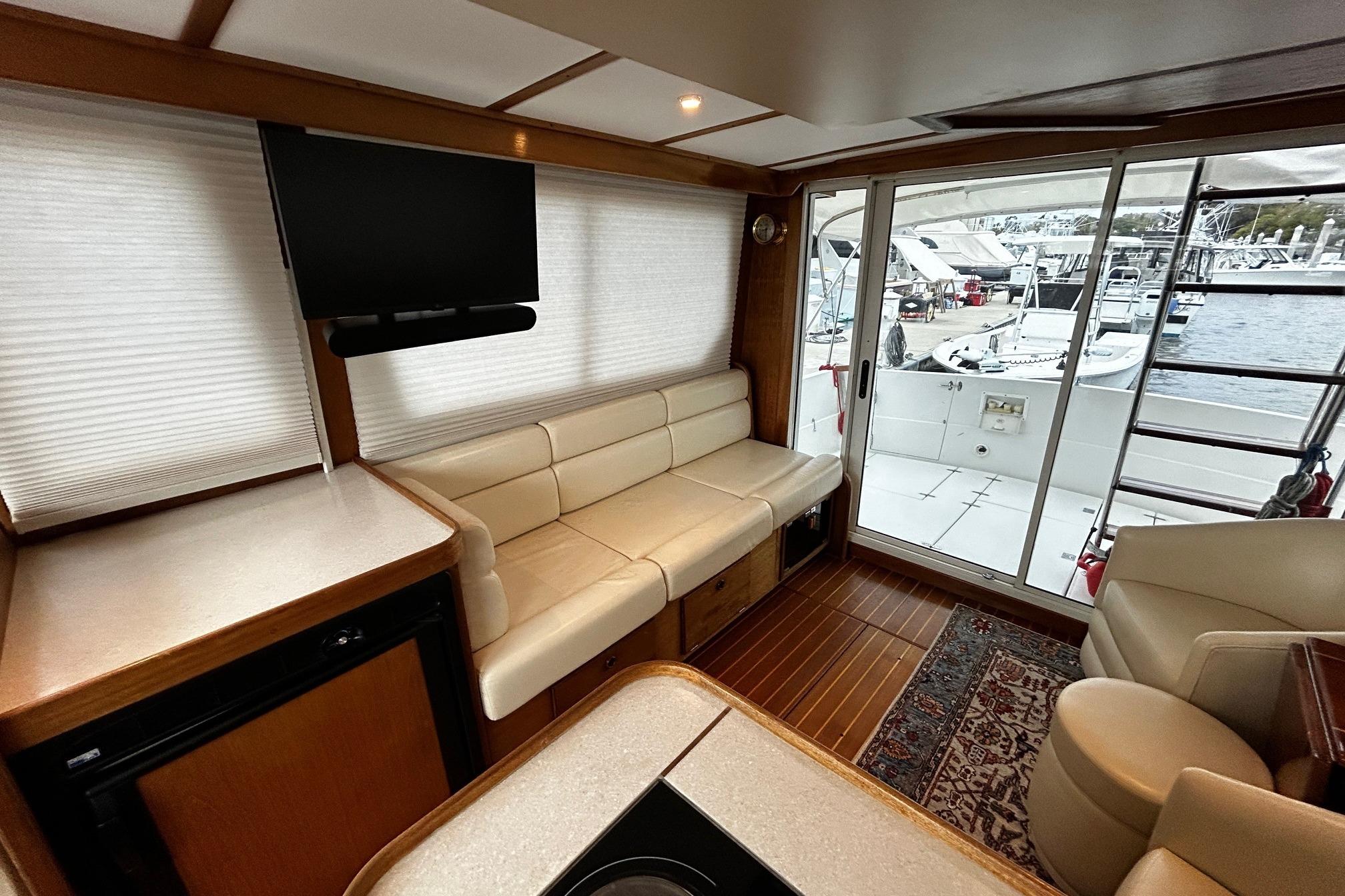 Interior of 2001 Sabre 34 yacht with seating, TV, and marina view.